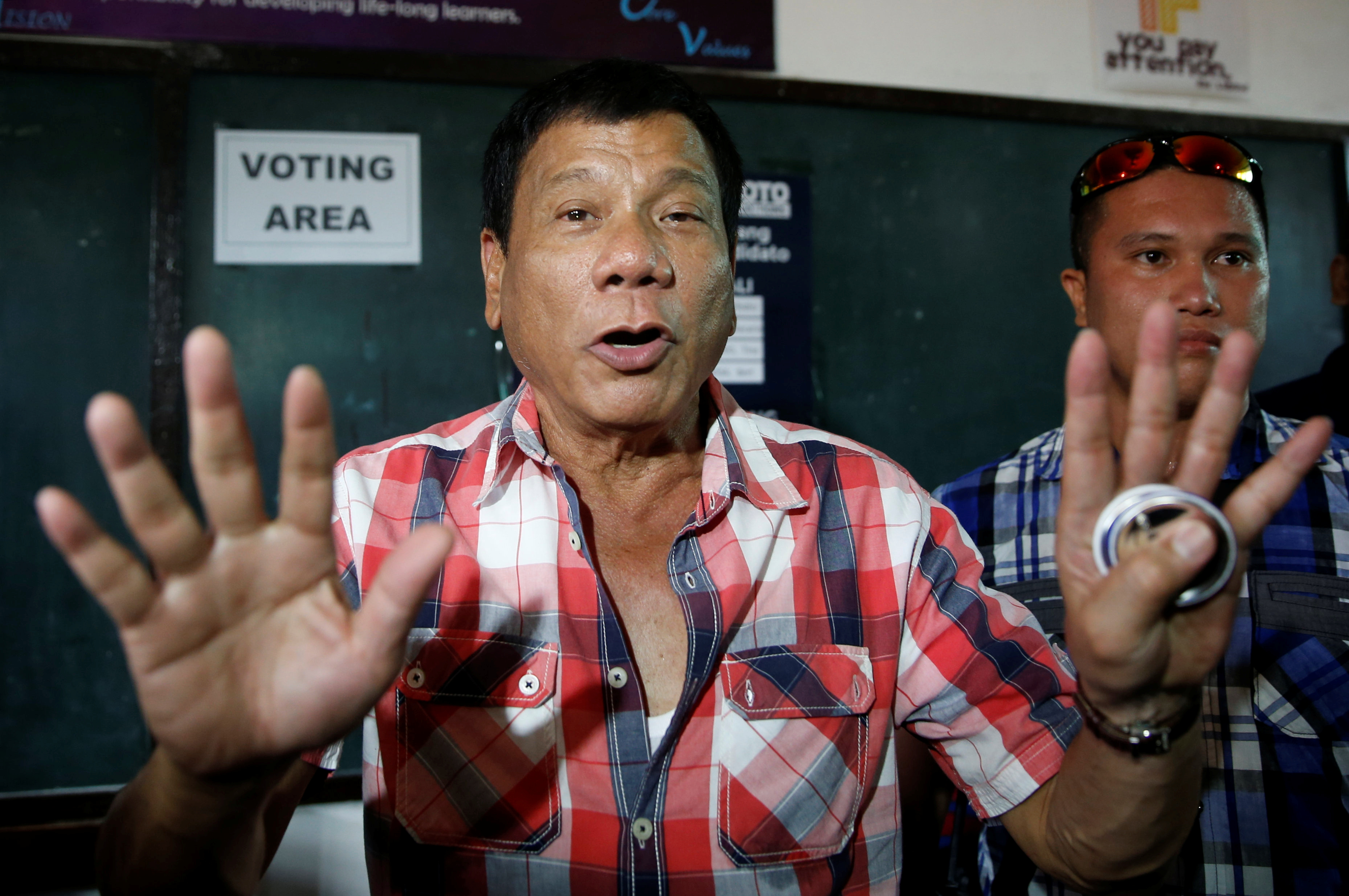 Presidential candidate Rodrigo Duterte talks to the media before casting his vote for national elections at Daniel Aguinaldo National High School in Davao City, in southern Philippines, on May 9, 2016 (Erik de Castro—Reuters)