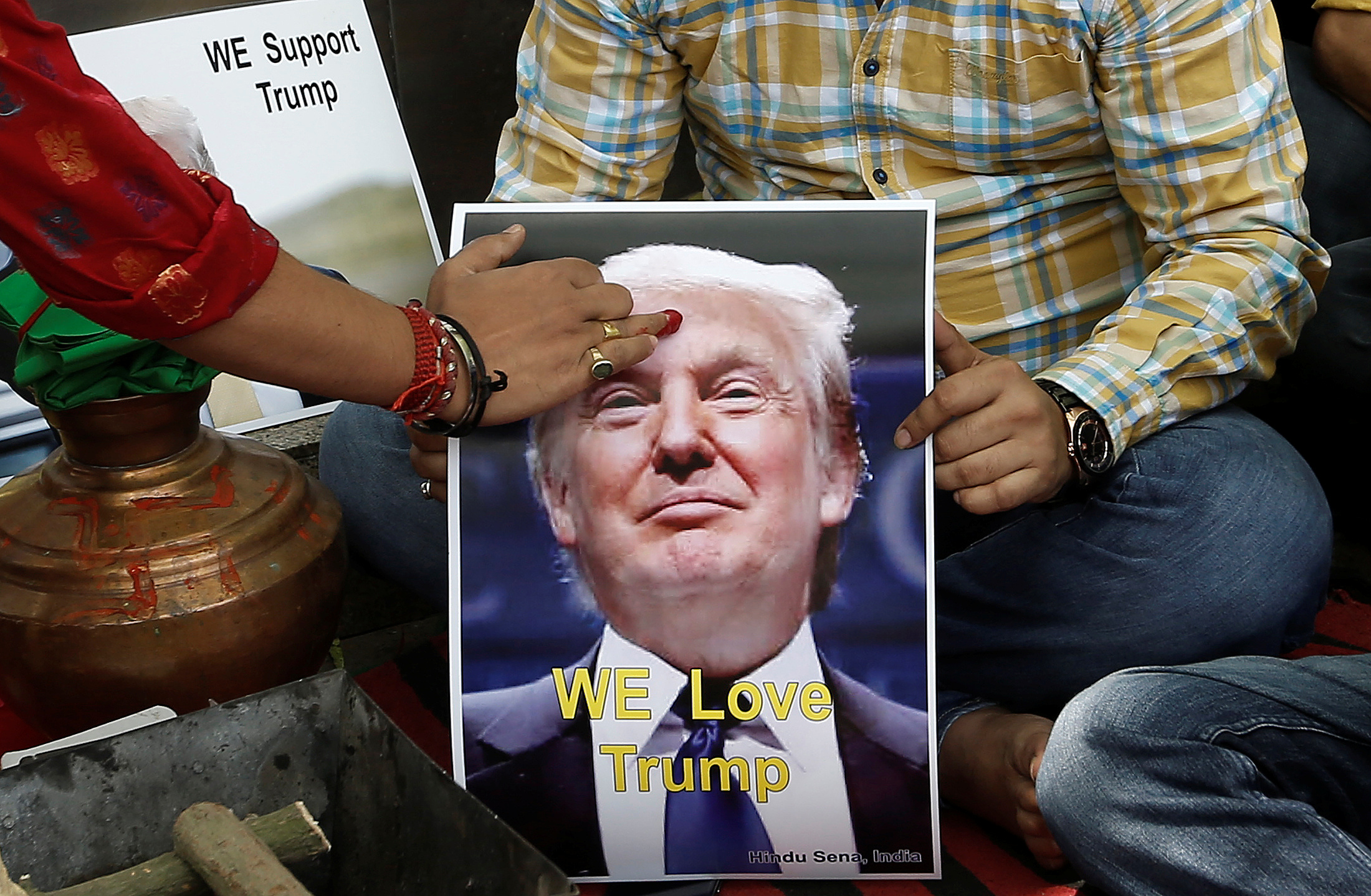 A priest applies a tika on the portrait of Republican U.S. presidential candidate Trump during a special prayer to ensure his victory in New Delhi