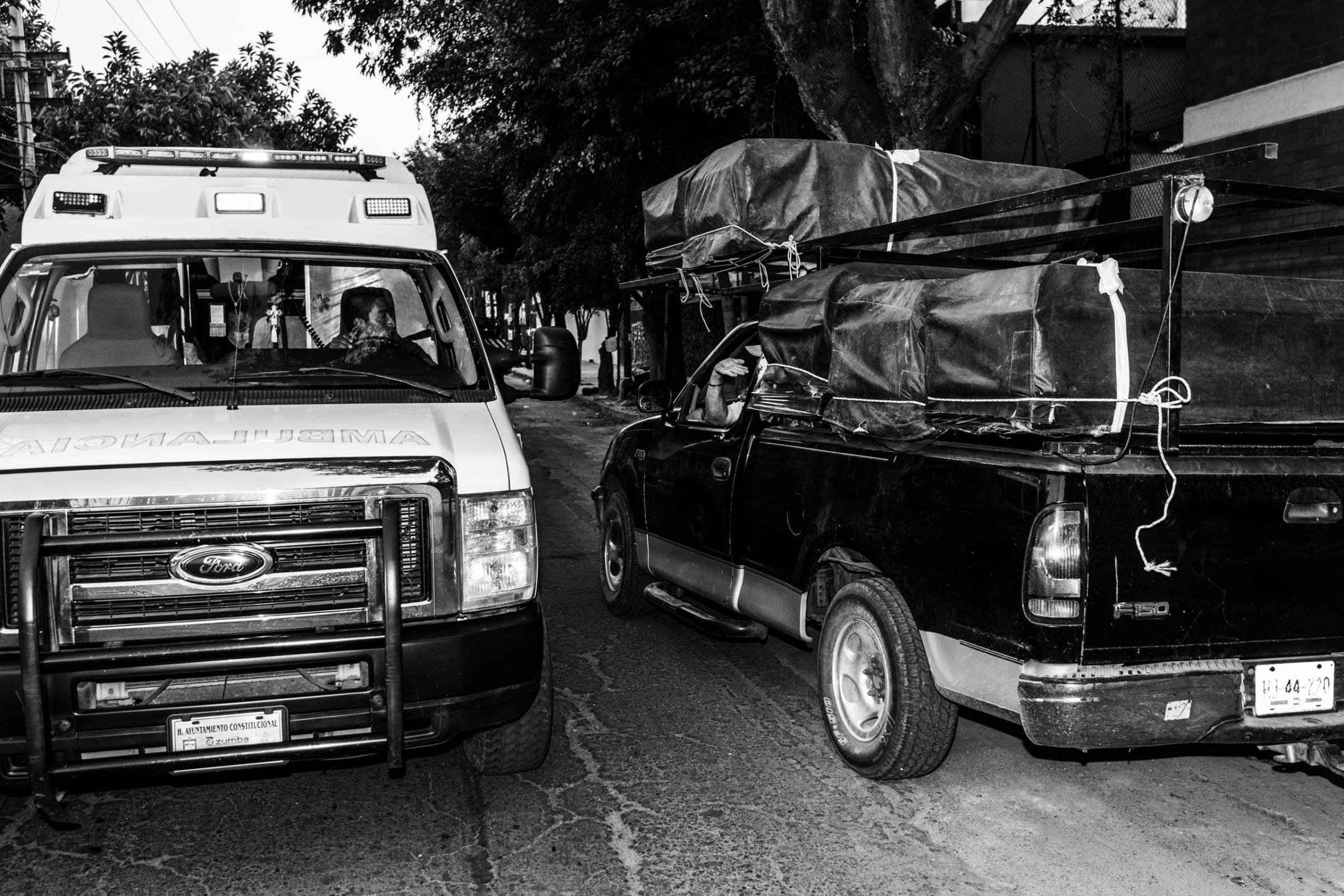 Itinerant coffins sellers are talking to an ambulance in order to gather info about the funerals stores in need of coffins. Mexico City, Colonia Doctores, Mexico on March 13, 2016.