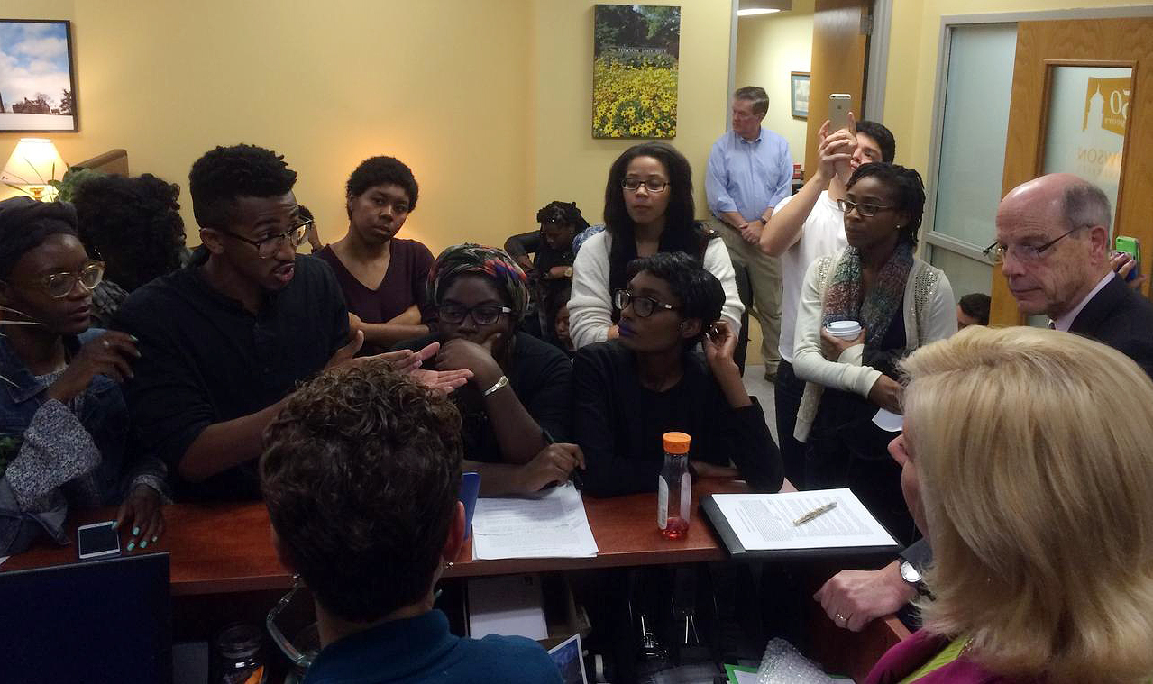 Student activists, including Bilphena Yahwon, left, and John Gillespie, second left, talk with administrators, including then-Interim President Timothy Chandler, right, at a student-led sit-in of the president's office at Towson University on Nov. 18, 2015. (Cody Boteler—The Towerlight (www.thetowerlight.com))