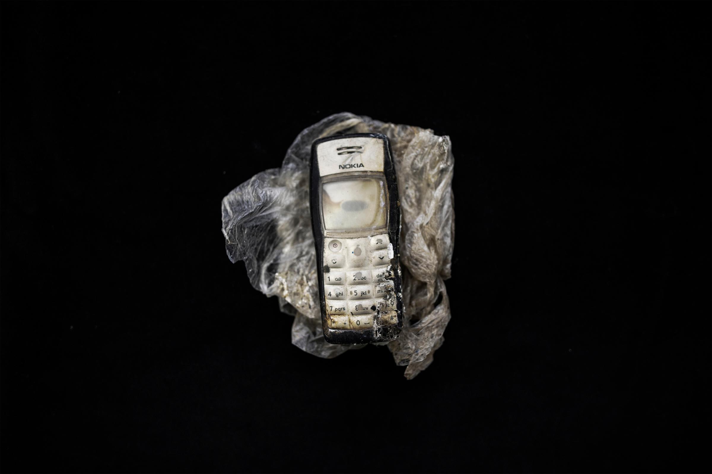 A mobile phone that belonged to a migrant deceased during a Oct. 3, 2013 shipwreck off the Italian island of Lampedusa. Nearly 200 victims remain unidentified, Milan, Italy - Sept. 30, 2015.