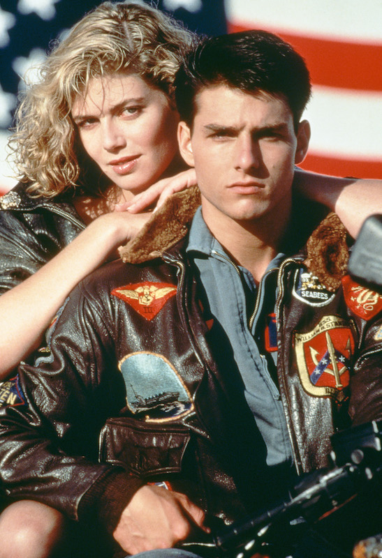 American actors Tom Cruise, as Lieutenant Pete 'Maverick' Mitchell, and Kelly McGillis, as Charlotte 'Charlie' Blackwood, in a promotional portrait for 'Top Gun', directed by Tony Scott, 1986. (Paramount Pictures / Getty Images)