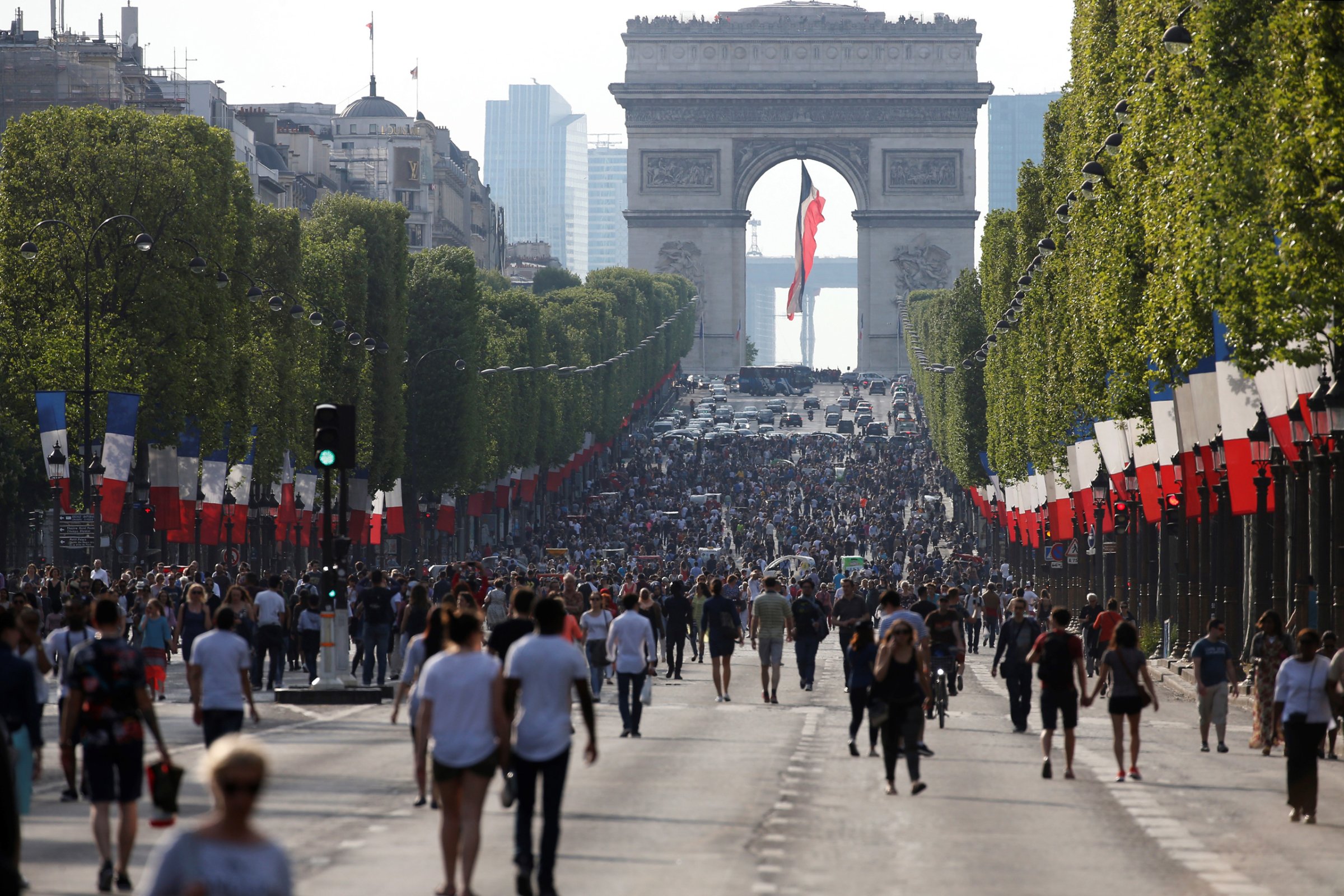People walk along the Champs Elysees Avenue on May 8, 2016, as the French capital's most famous avenue goes car-free for a day, in the first instalment of a monthly effort to tackle pollution in Paris. / AFP / THOMAS SAMSON (Photo credit should read THOMAS SAMSON/AFP/Getty Images)