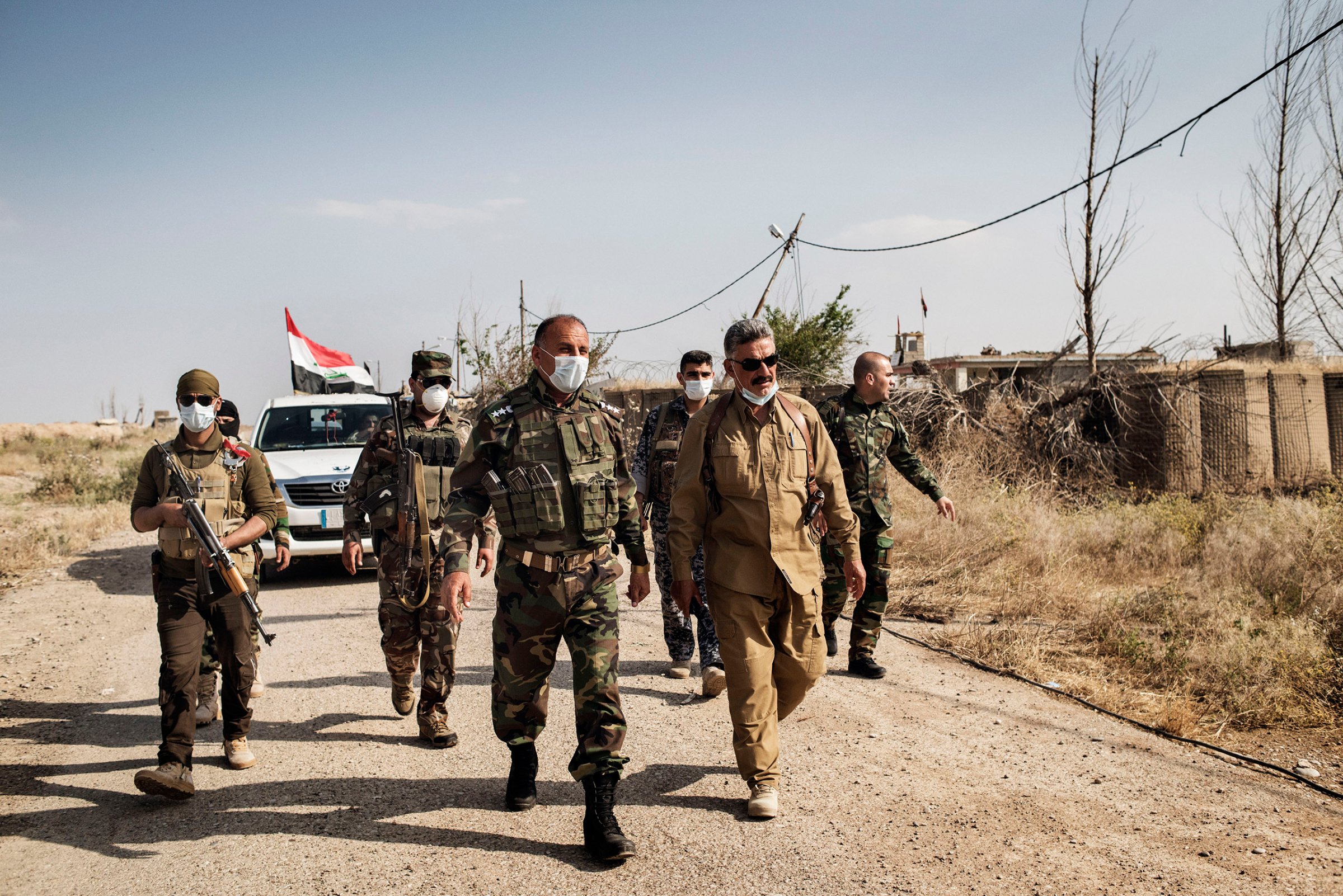 Zaki Kamal Hussein, commander of a local Turkmen-led branch of Iraq's Popular Mobilization militias, and police official Mahmoud Ali inspect the site of an alleged chemical weapons attack in the town of Bashir, Iraq, May 10, 2016.