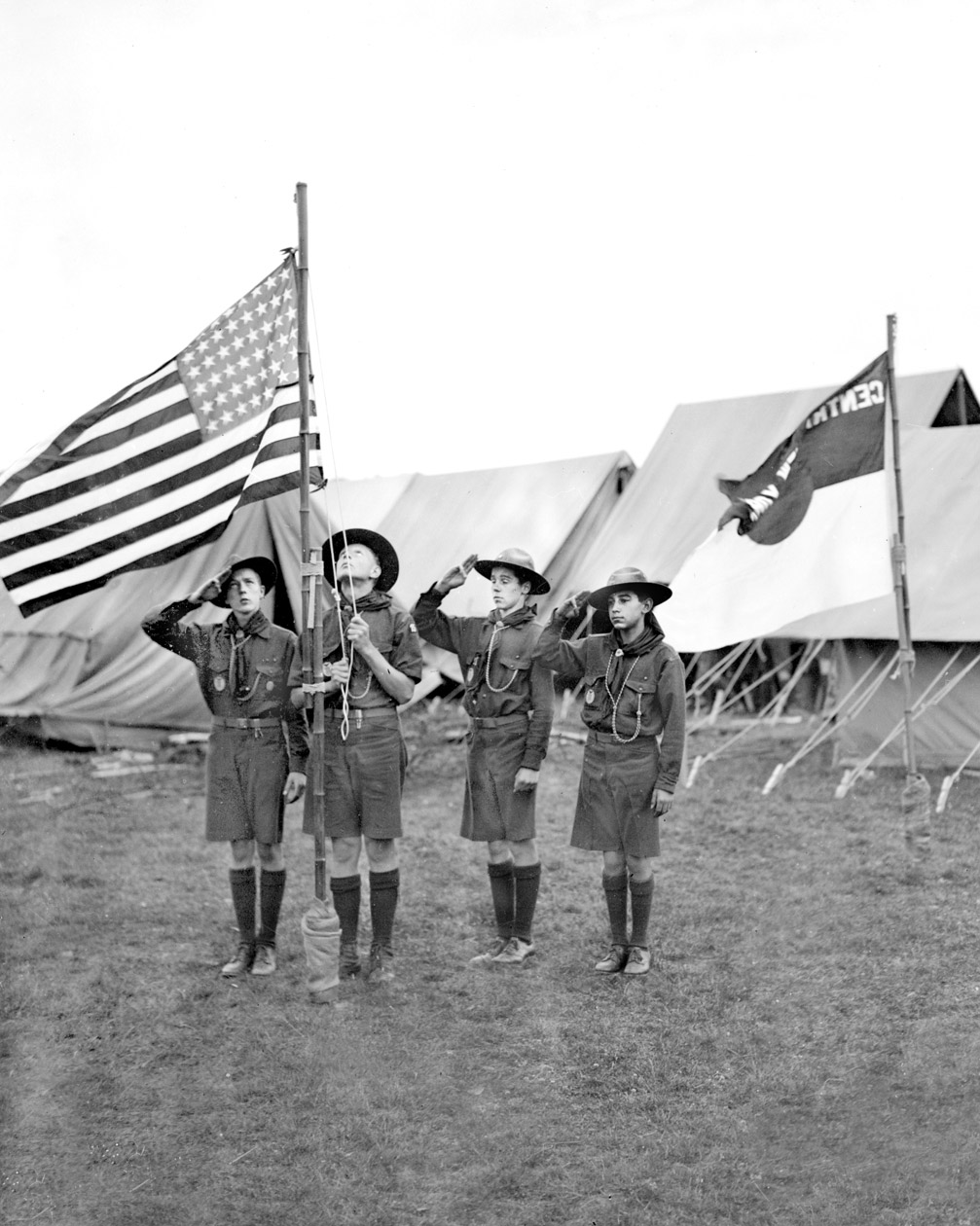 American boy scouts from New York, hauling up the American flag in front of their camp at Arrowe Park, Birkenhead in readiness for the International Scout Jamboree. United Kingdom, 1929.
