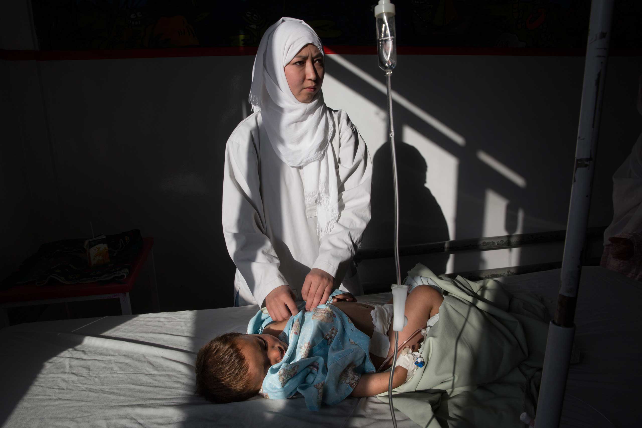 Karima Mehrabi, a pediatric nurse, cares for an infant in the women and children's ward at the Emergency hospital in Kabul on March 21, 2016.
