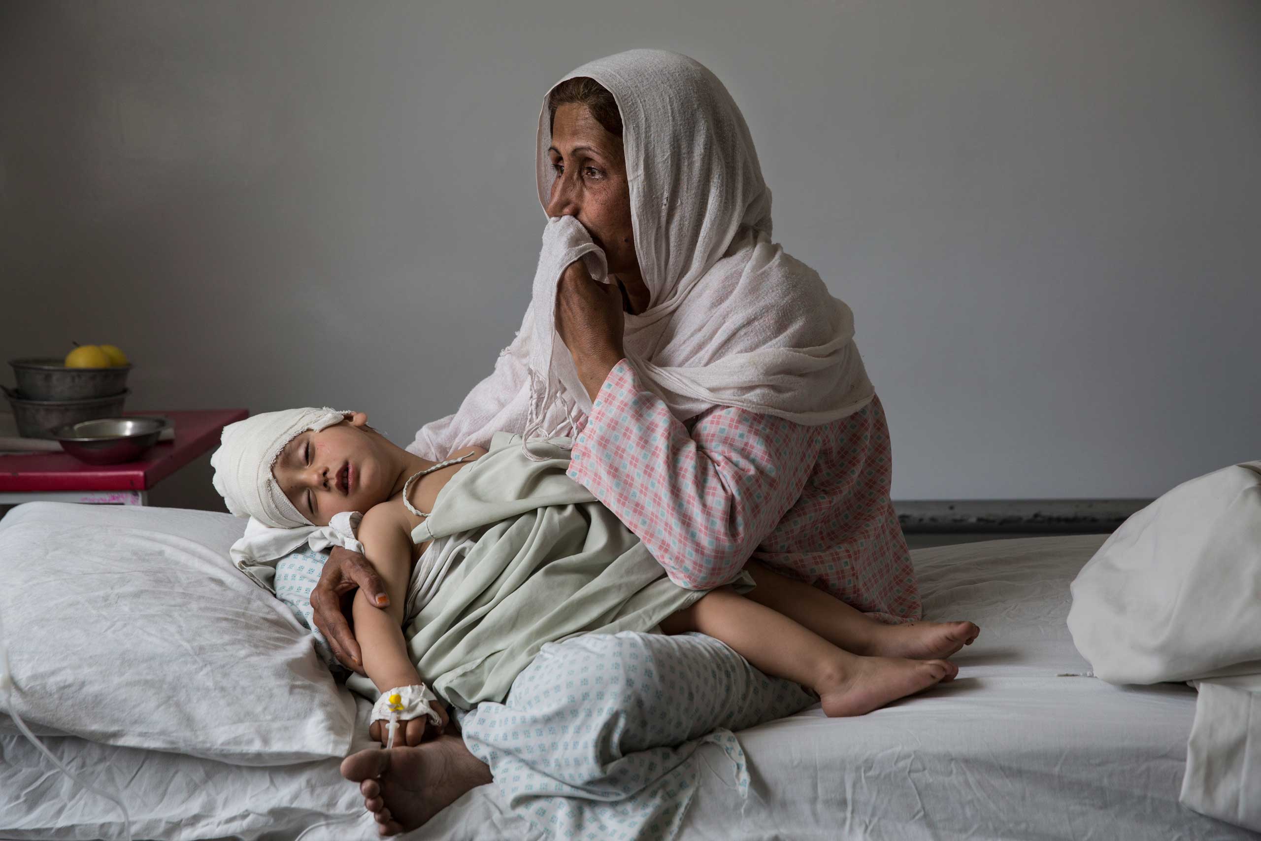At the Emergency hospital, Najiba holds her nephew, Shabir, 2,  who was injured from a bomb blast which killed his sister in Kabul on March 29, 2016. Najiba had to stay with the children as their mother buried her daughter.