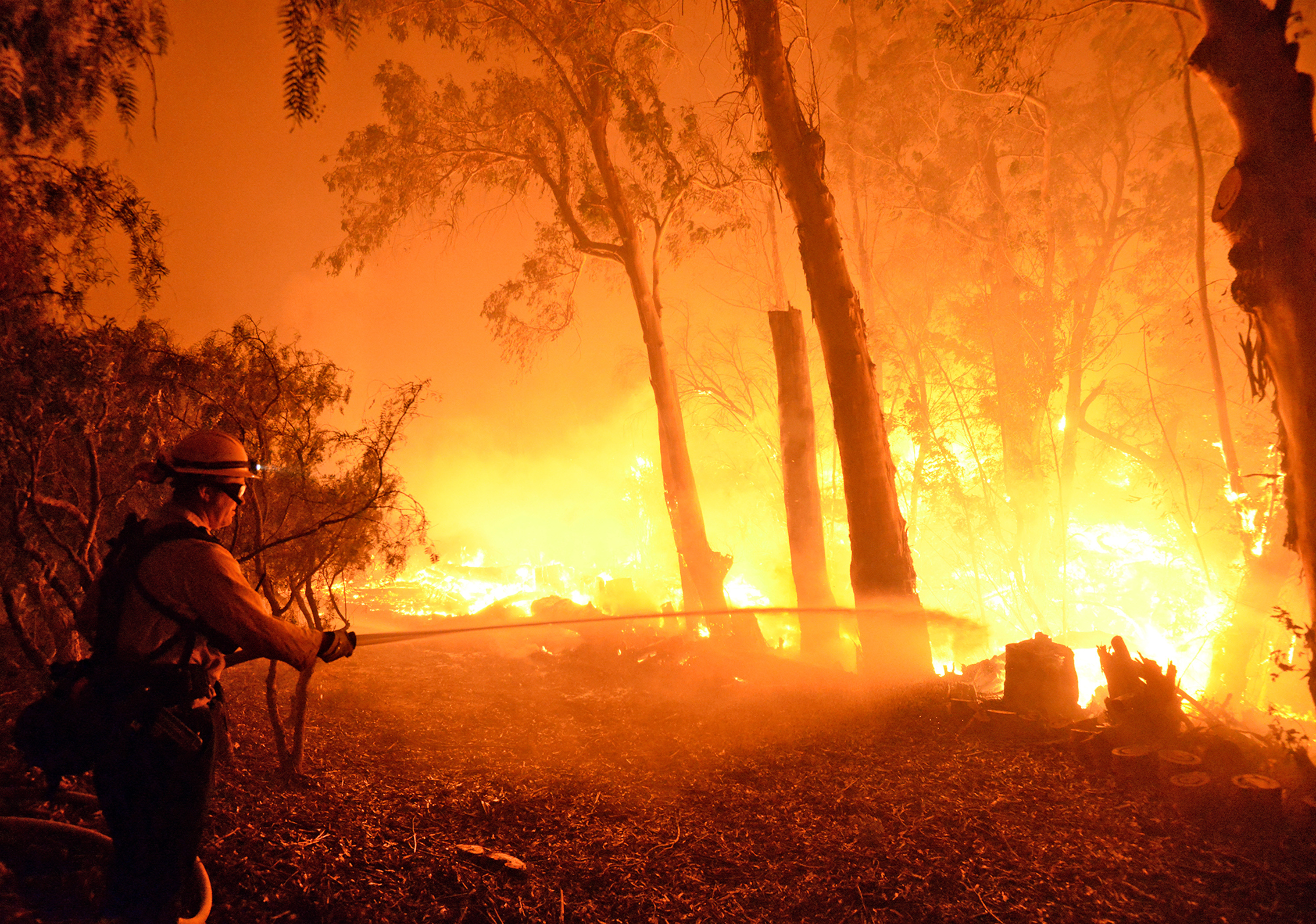 A firefighter knocks down flames as they approach a ranch near the Las Flores Canyon area west of Goleta, Calif., in the early morning hours of Thursday, June 16, 2016 (Mike Eliason&mdash;AP)