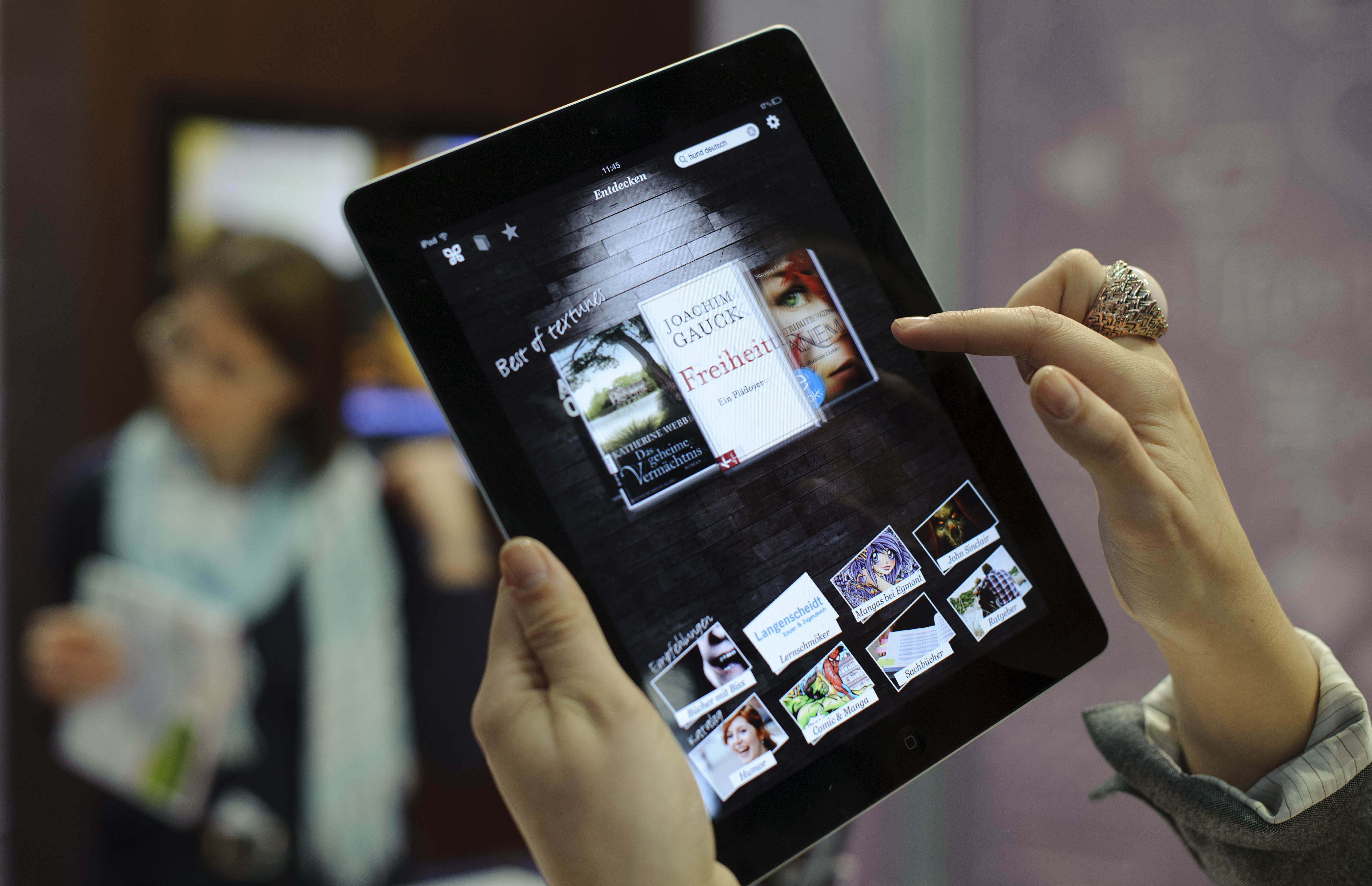 Fair goers try out the eBook reader app on an Apple iPad at a book fair on March 15, 2012. (Robert Michael—AFP/Getty Images)