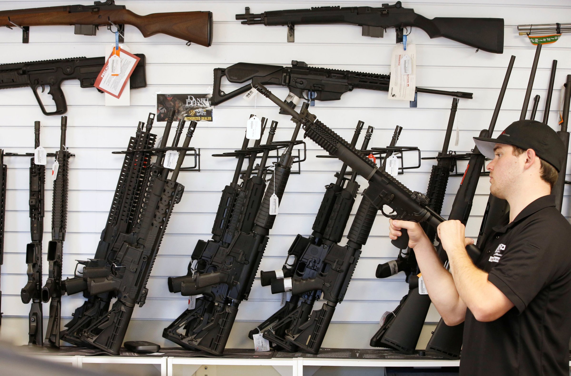 A salesman clears the chamber of an AR-15 at the "Ready Gunner" gun store in Provo, Utah on June 21, 2016.