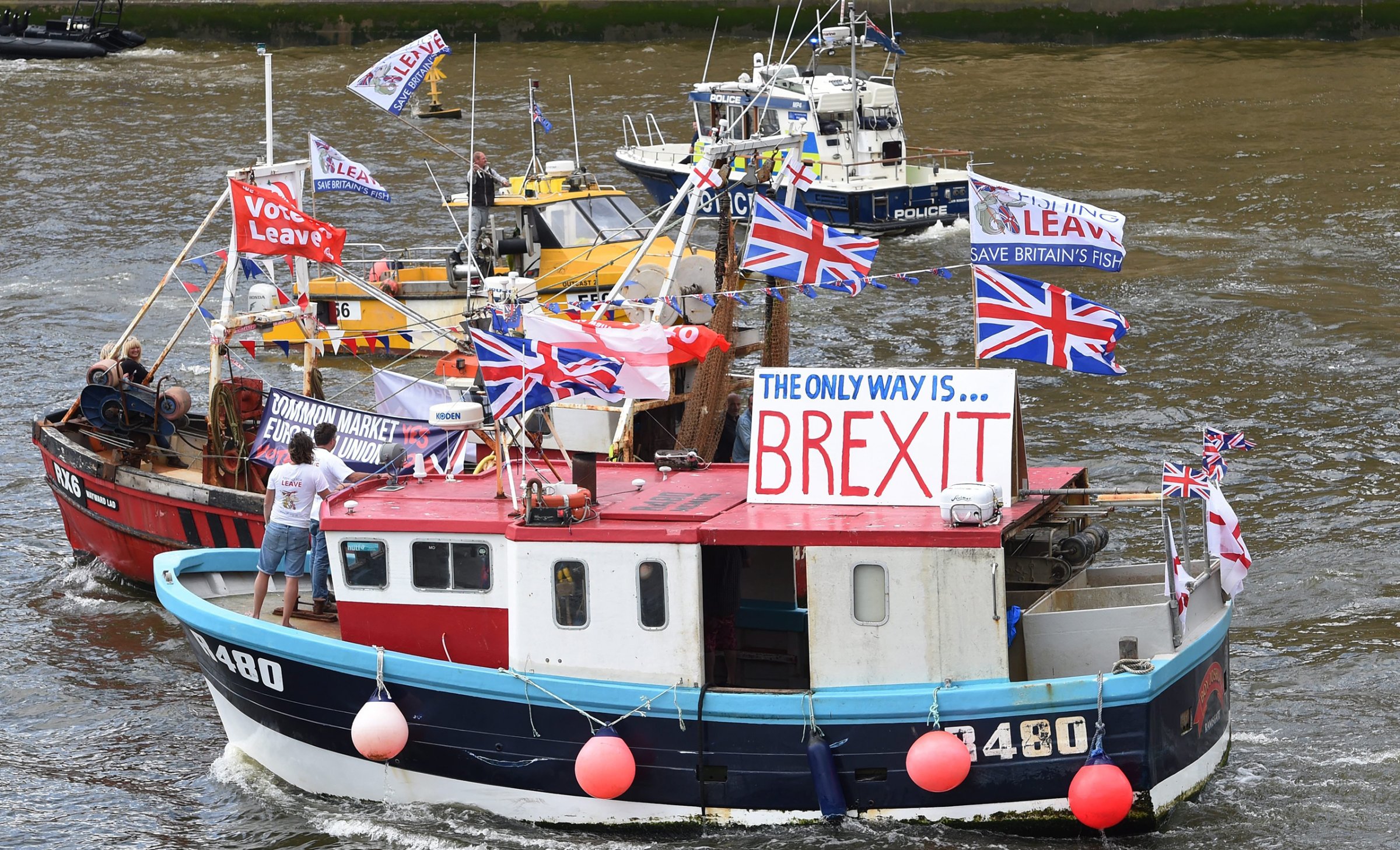 A flotilla of fishing trawlers, organized by UKIP leader Nigel Farage, sails up the river Thames next to the Houses of Parliament in London, June 15, 2016.
