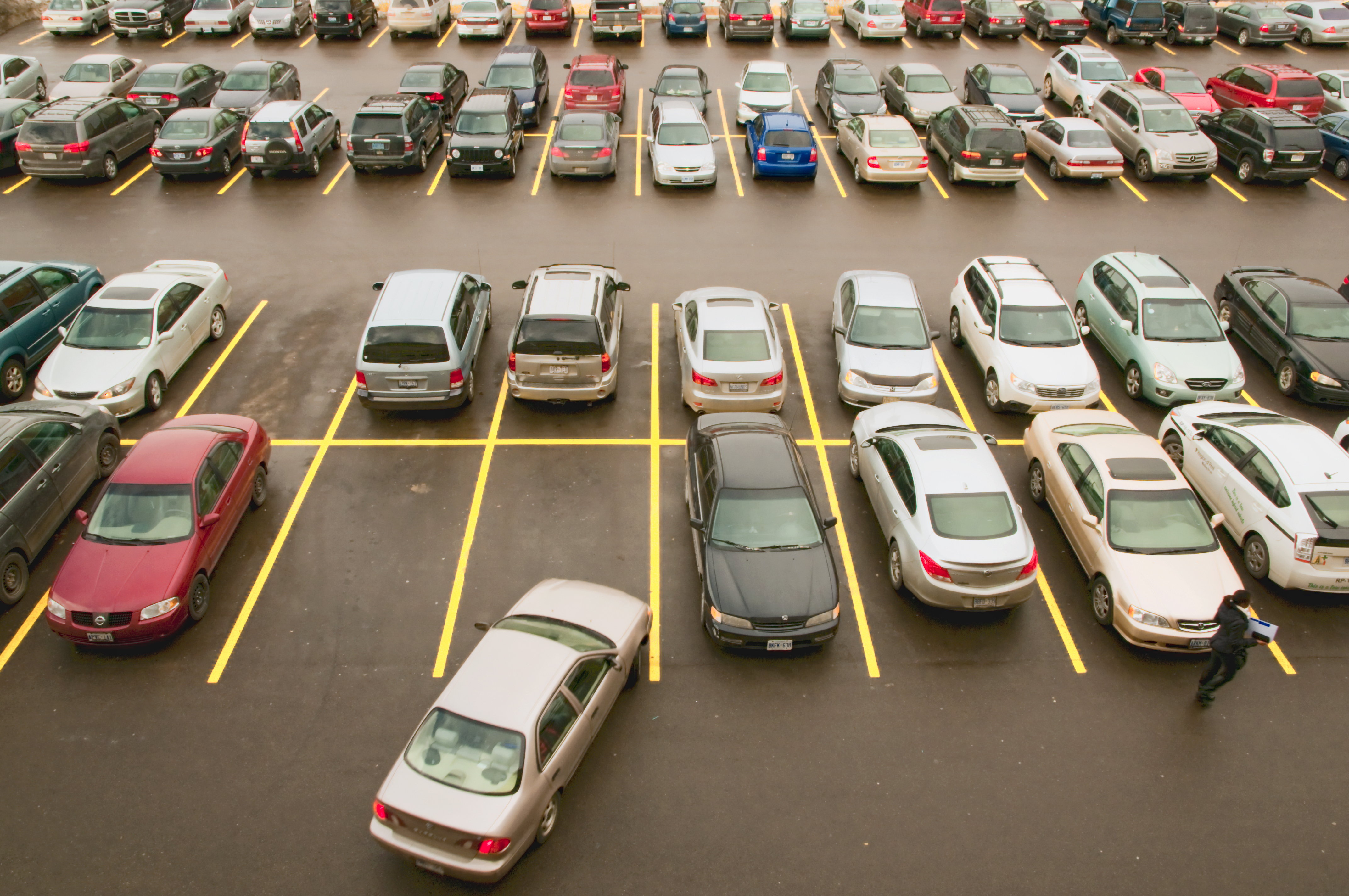 Top view looking down on parking lot, full with cars and shopper walking. (Gail Shotlander—Getty Images)