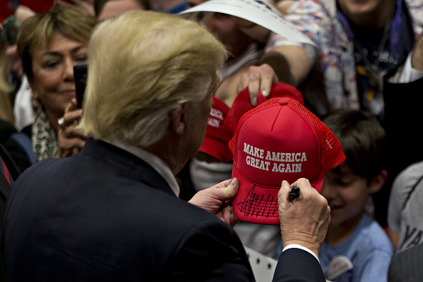 Donald Trump, president and chief executive of Trump Organization Inc. and 2016 Republican presidential candidate, signs a campaign hat after speaking during a campaign rally at West Chester University in West Chester, Pennsylvania, U.S., on Monday, April 25, 2016.
