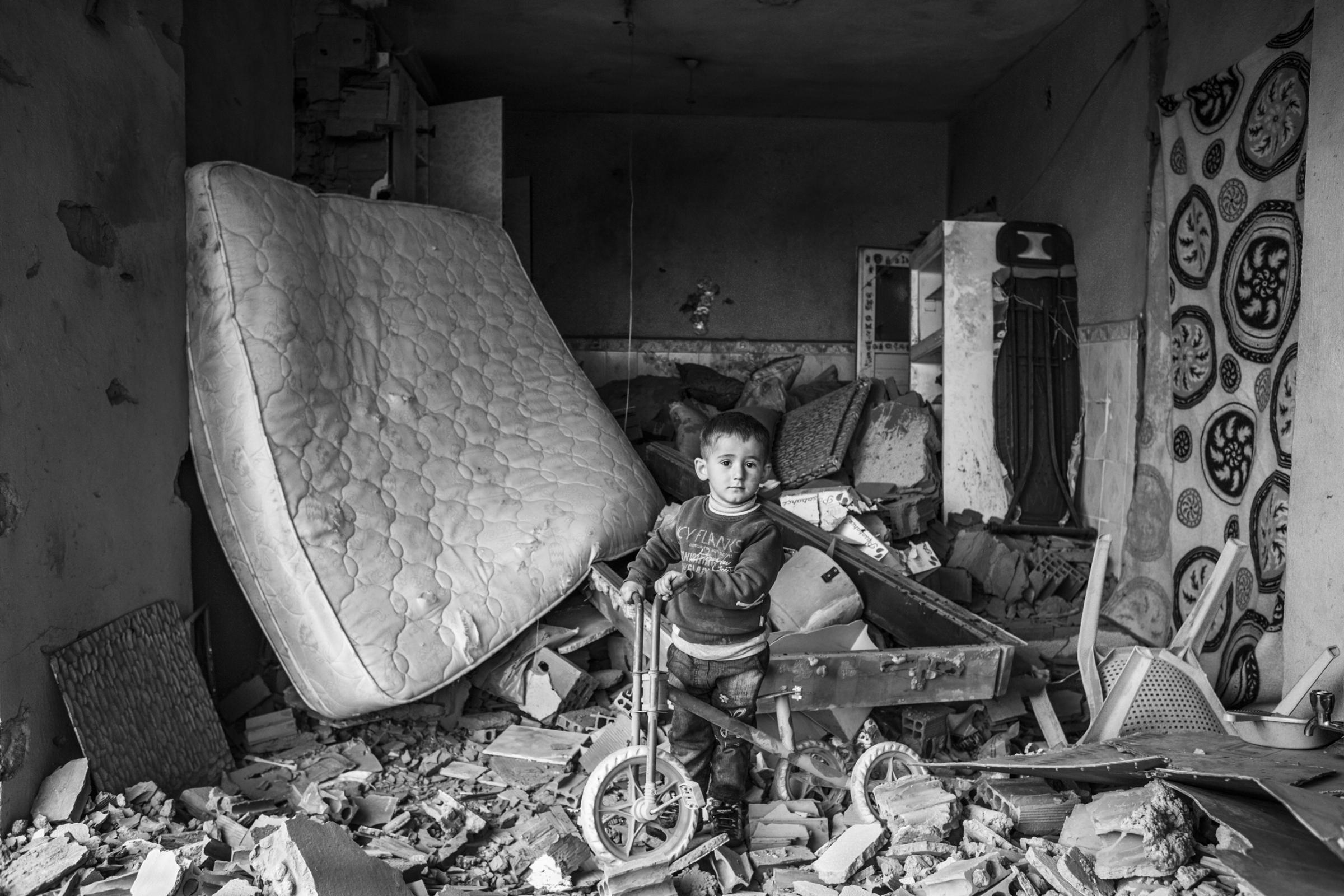 A child plays in his house that was damaged during fighting between government troops and separatist Kurdistan Workers Party (PKK) fighters, in the Kurdish town of Silopi, southeastern Turkey, near the border with Iraq, Jan. 2016.