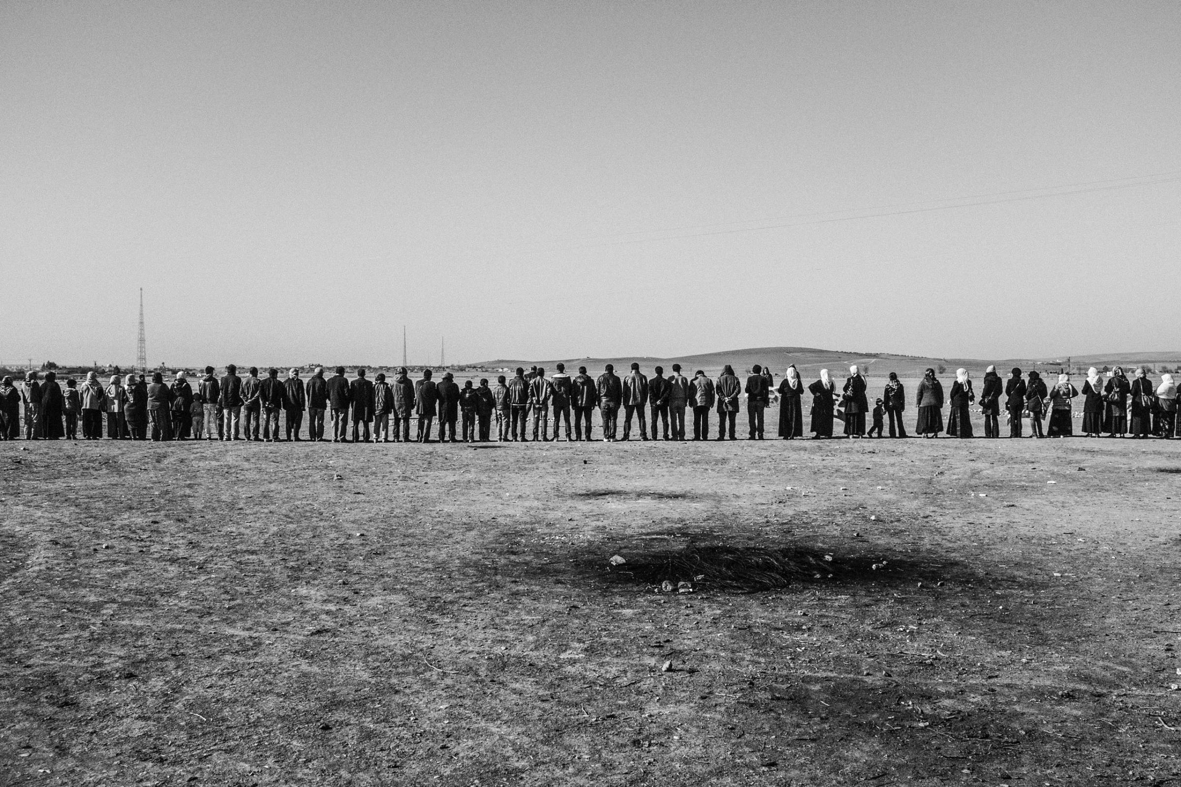 Refugees from Kobani, Syria line up at the Turkish-Syrian border in Suruc, Turkey to support the Kurds fighting against ISIS, Jan. 2015