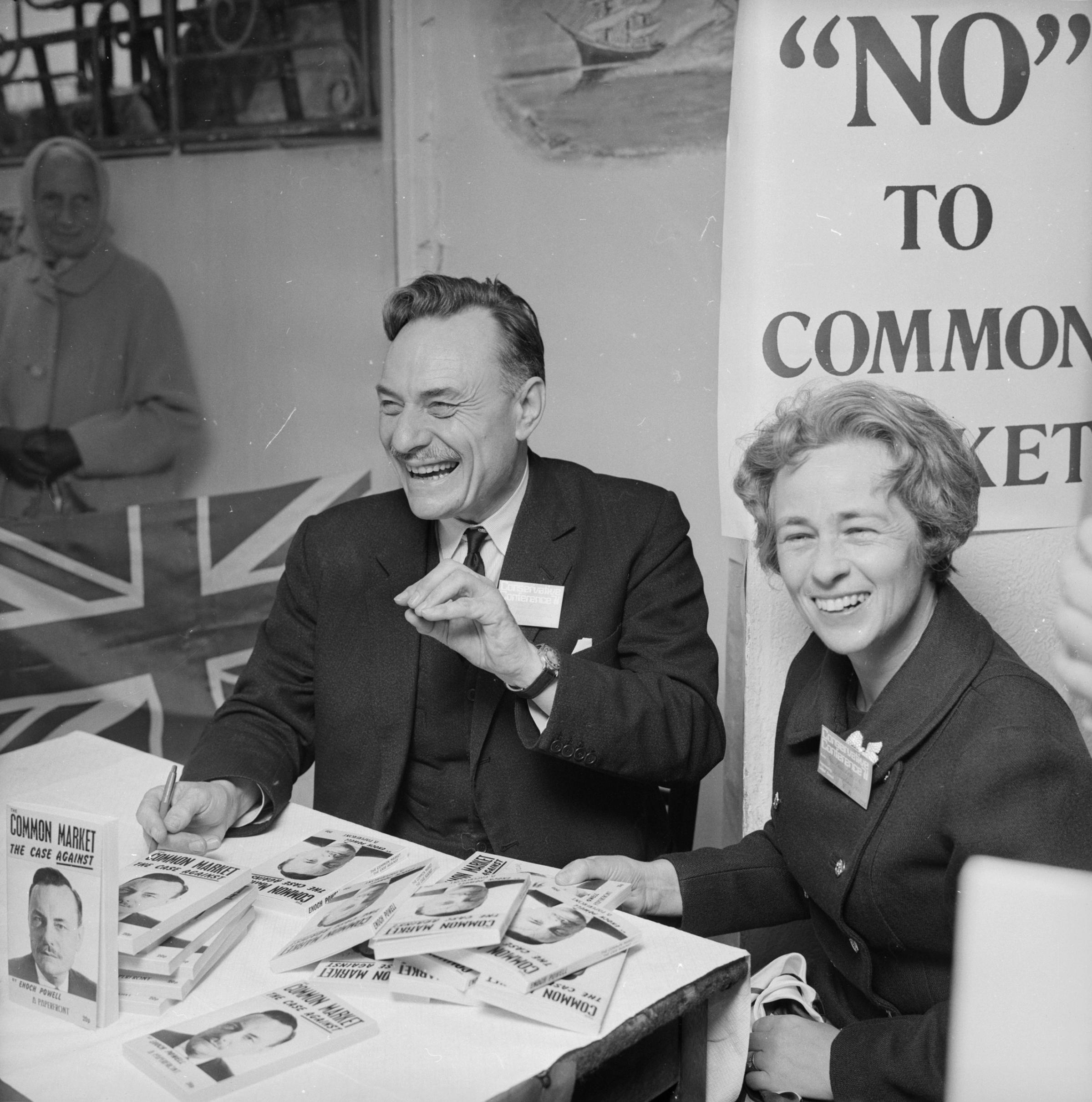 English Conservative politician, (John) Enoch Powell with his wife as he signs copies of his book 'Common Market - The Case Against' during the Conservative Party Conference in Brighton, Oct. 13, 1971