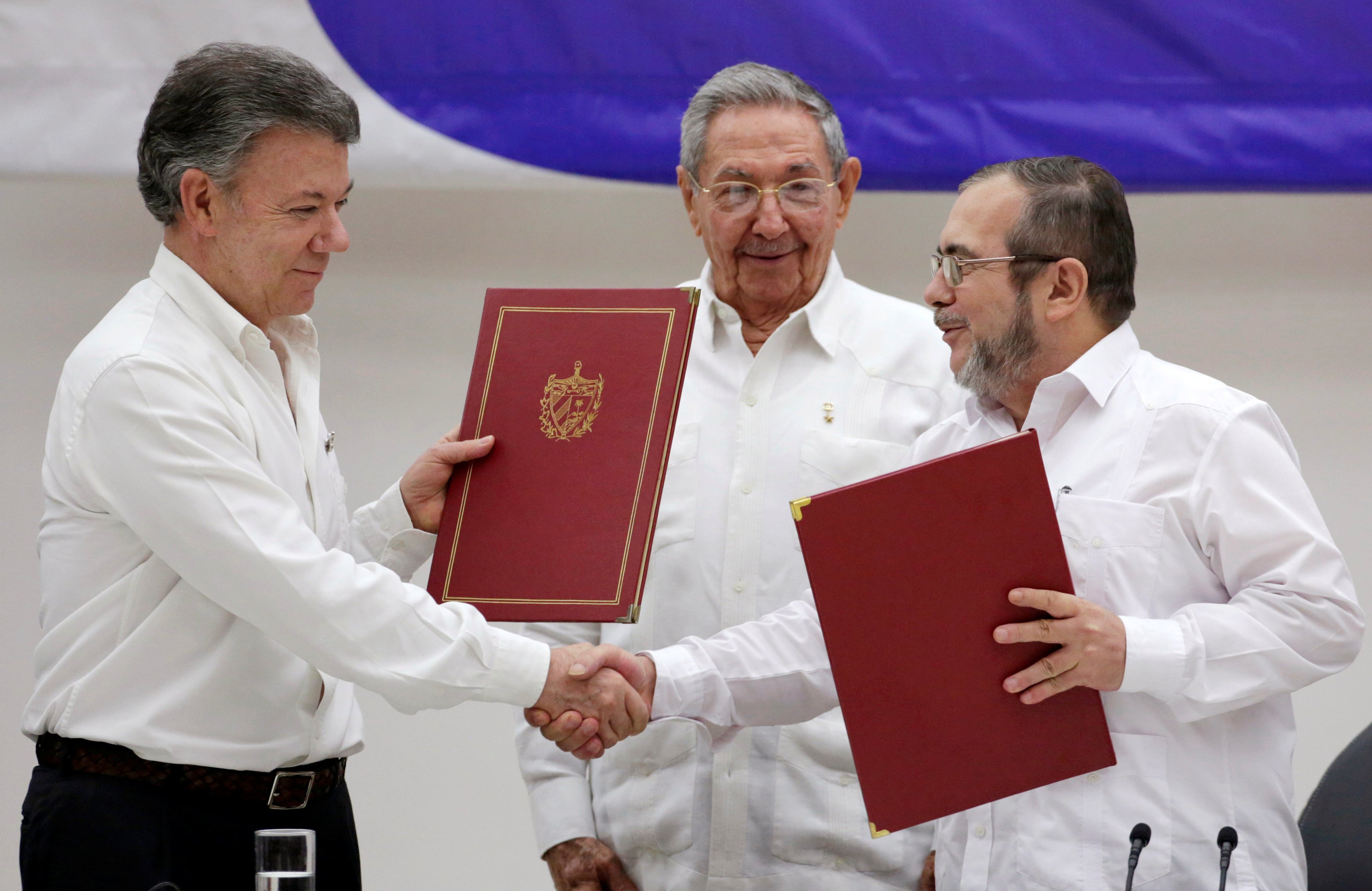 Cuba's President Raul Castro (C), Colombia's President Juan Manuel Santos (L) and FARC rebel leader Rodrigo Londono, react after the signing of a ceasefire deal in Havana, on June 23, 2016. (Enrique de la Osa—Reuters)