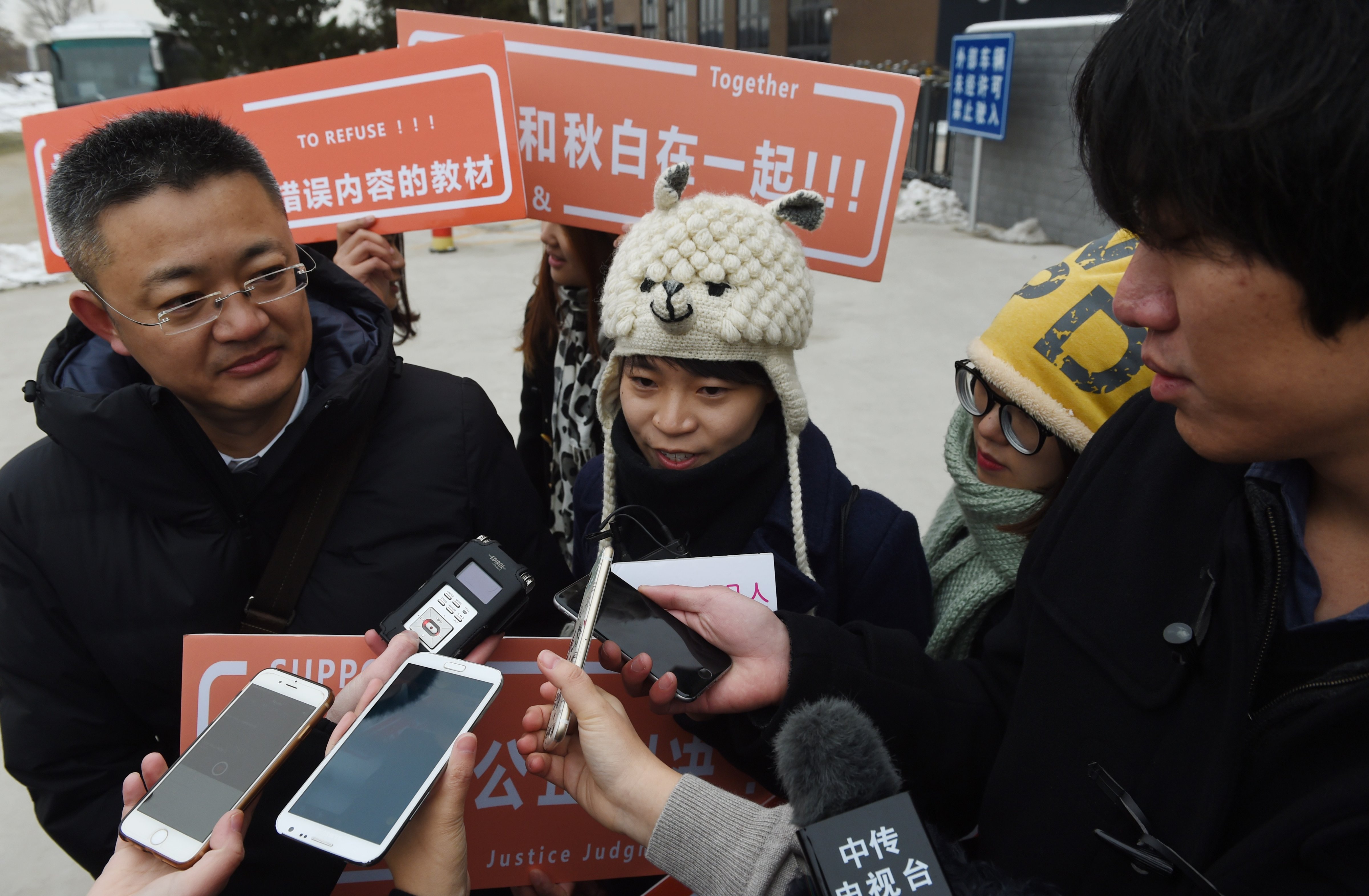 A Chinese lesbian (C), who goes by the pseudonym Qui Bai, speaks to the media with her lawyer Wang Zhenyu (L) before entering the Beijing No.1 Intermediate People's Court in Beijing on November 24, 2015. (GREG BAKER—AFP/Getty Images)
