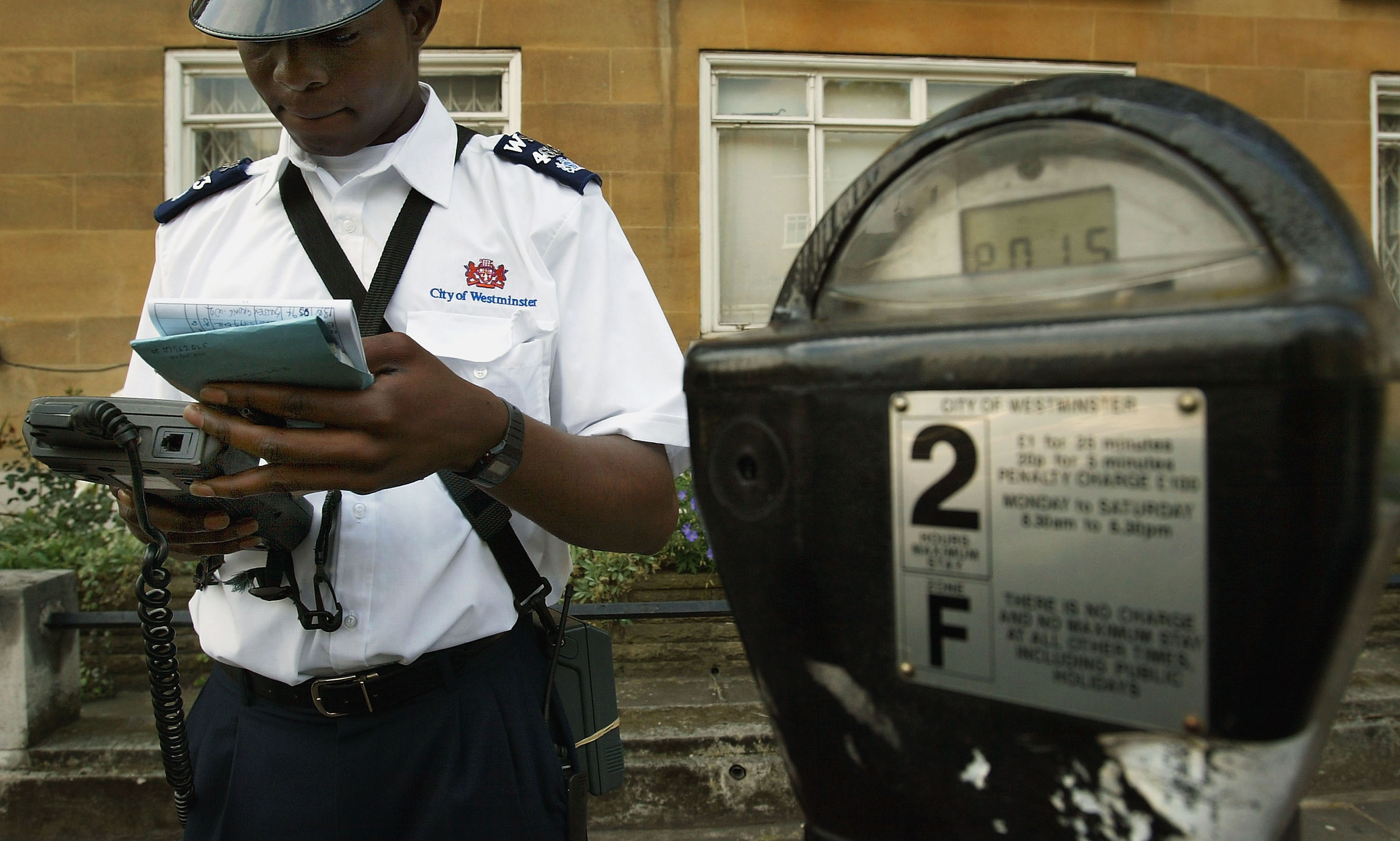 A Westminster traffic warden issues a parking ticket on July 7, 2004 in London, England. (Scott Barbour&mdash;Getty Images)