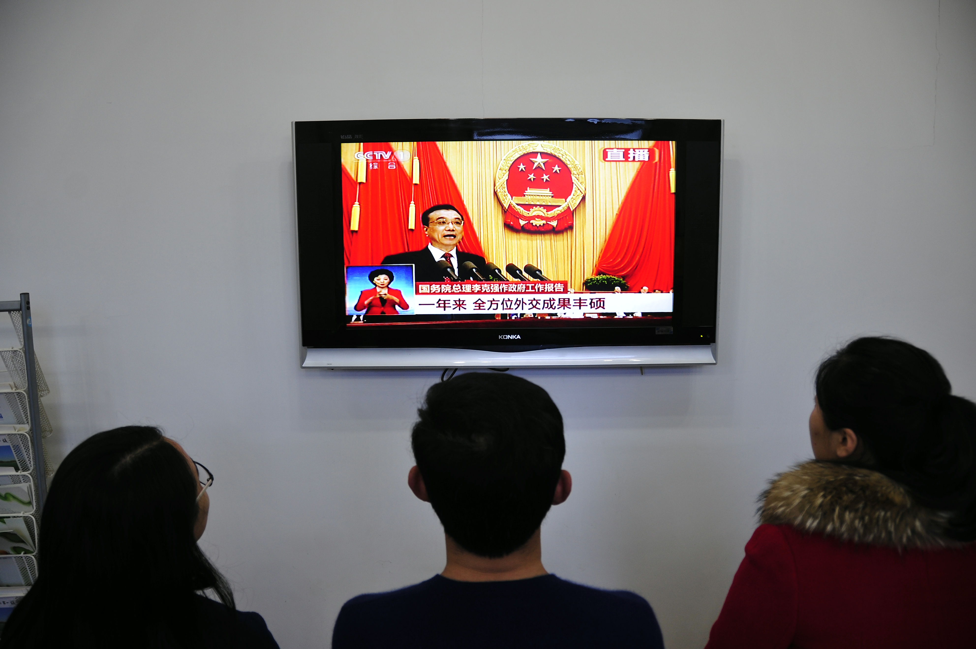 Chinese people watch live television coverage at a conference room in Yantai, east China's Shandong province as Chinese Premier Li Keqiang delivers his report during the opening ceremony of the National People's Congress in the Great Hall of the People in Beijing on March 5, 2016. (AFP/Getty Images)