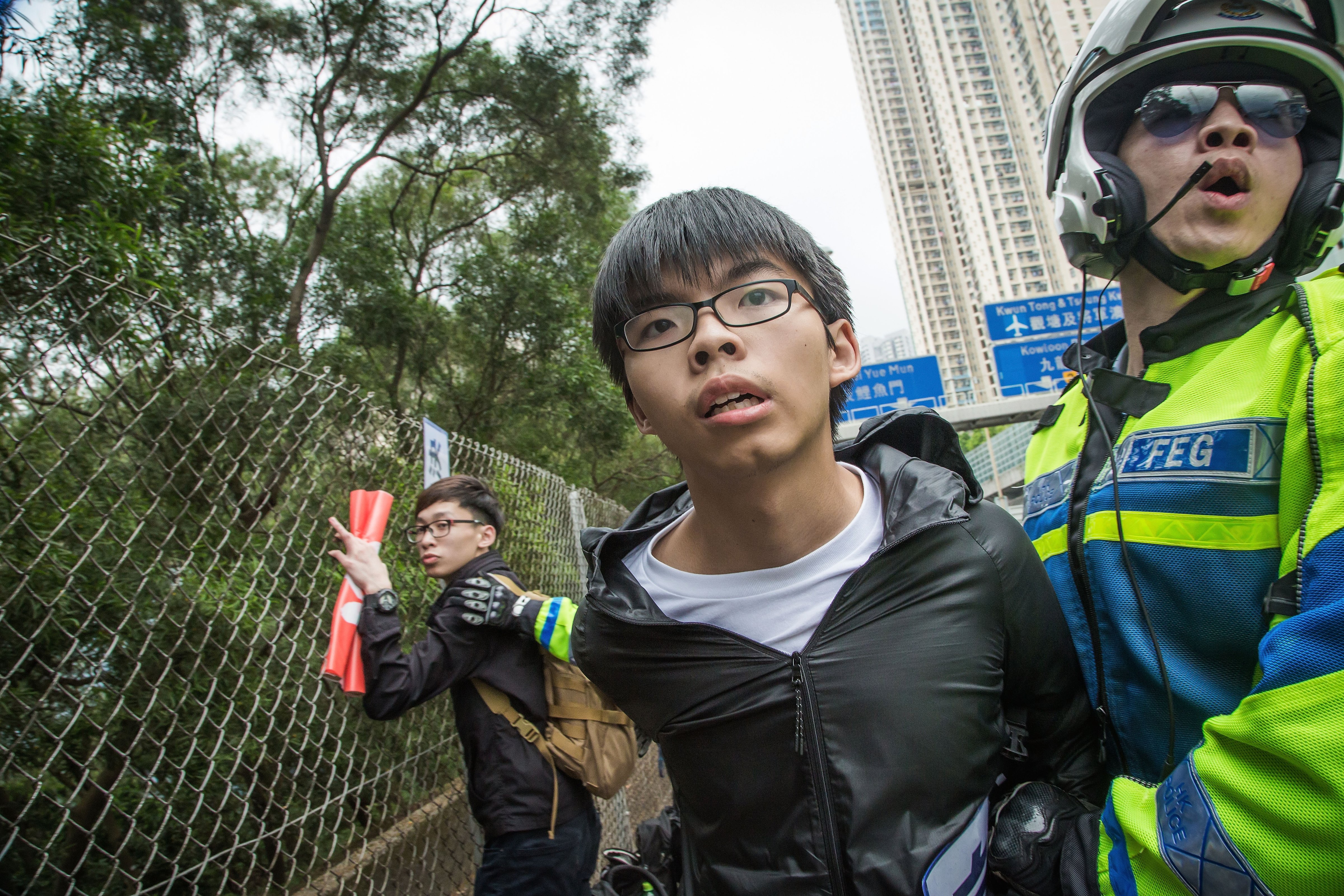 Joshua Wong, secretary general of political party Demosistō, is subdued by  police during an attempt to intercept the motorcade of top Chinese official Zhang Dejiang on May 19, 2016, in Hong Kong (Handout—Getty Images)