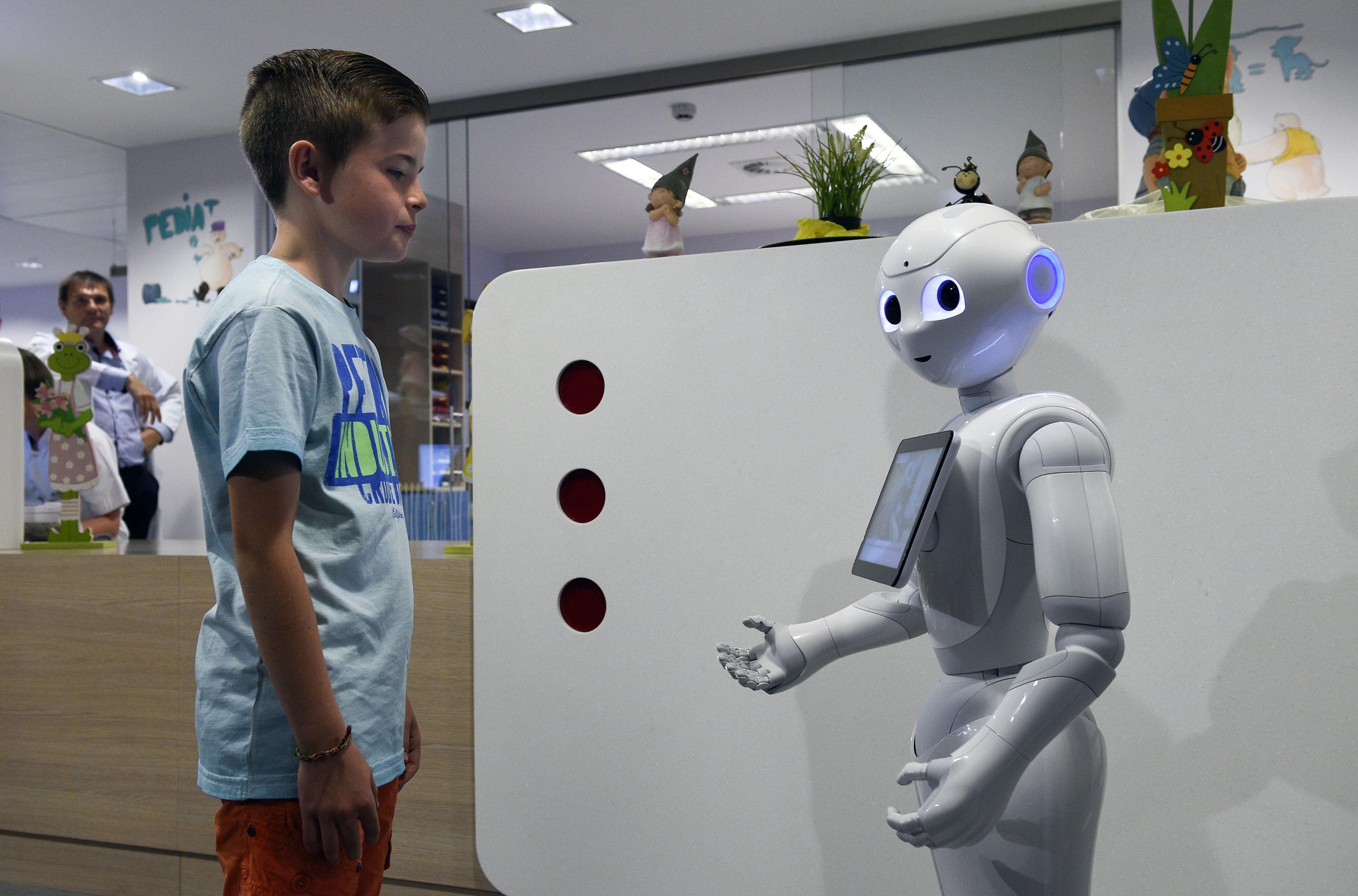 A young boy talks with the robot Pepper during a  press conference on June 13, 2016 at the CHR Citadel hospital centers of Liege (John Thys—AFP/Getty Images)