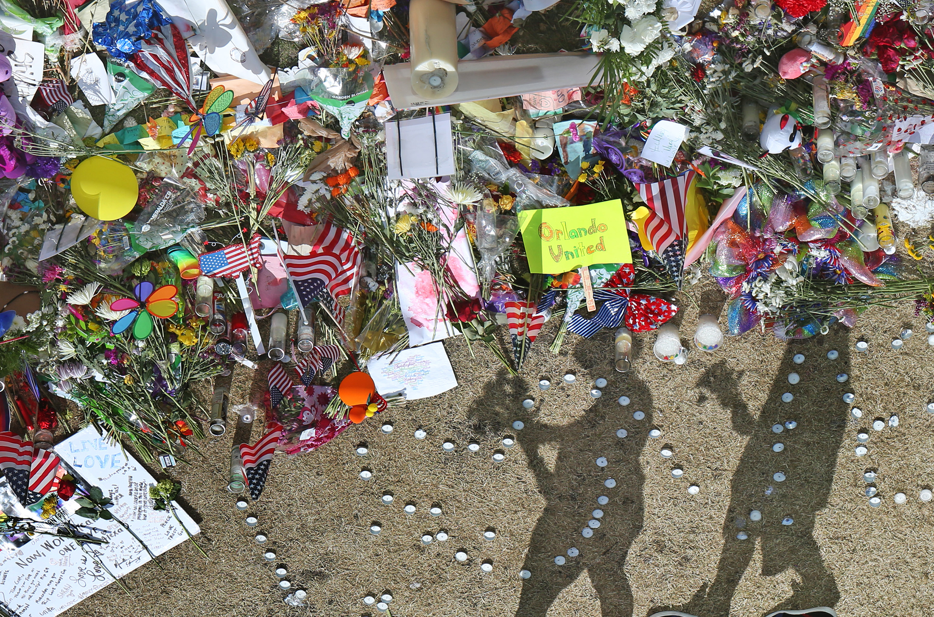 People pay their respects to an ever growing makeshift memorial at the Dr. Phillips Center for the Performing Arts in Orlando, Fla., on Monday, June 20, 2016, just north of the Pulse nightclub shooting scene where 49 people were killed. Orlando Sentinel—TNS via Getty Images (Orlando Sentinel—TNS via Getty Images)