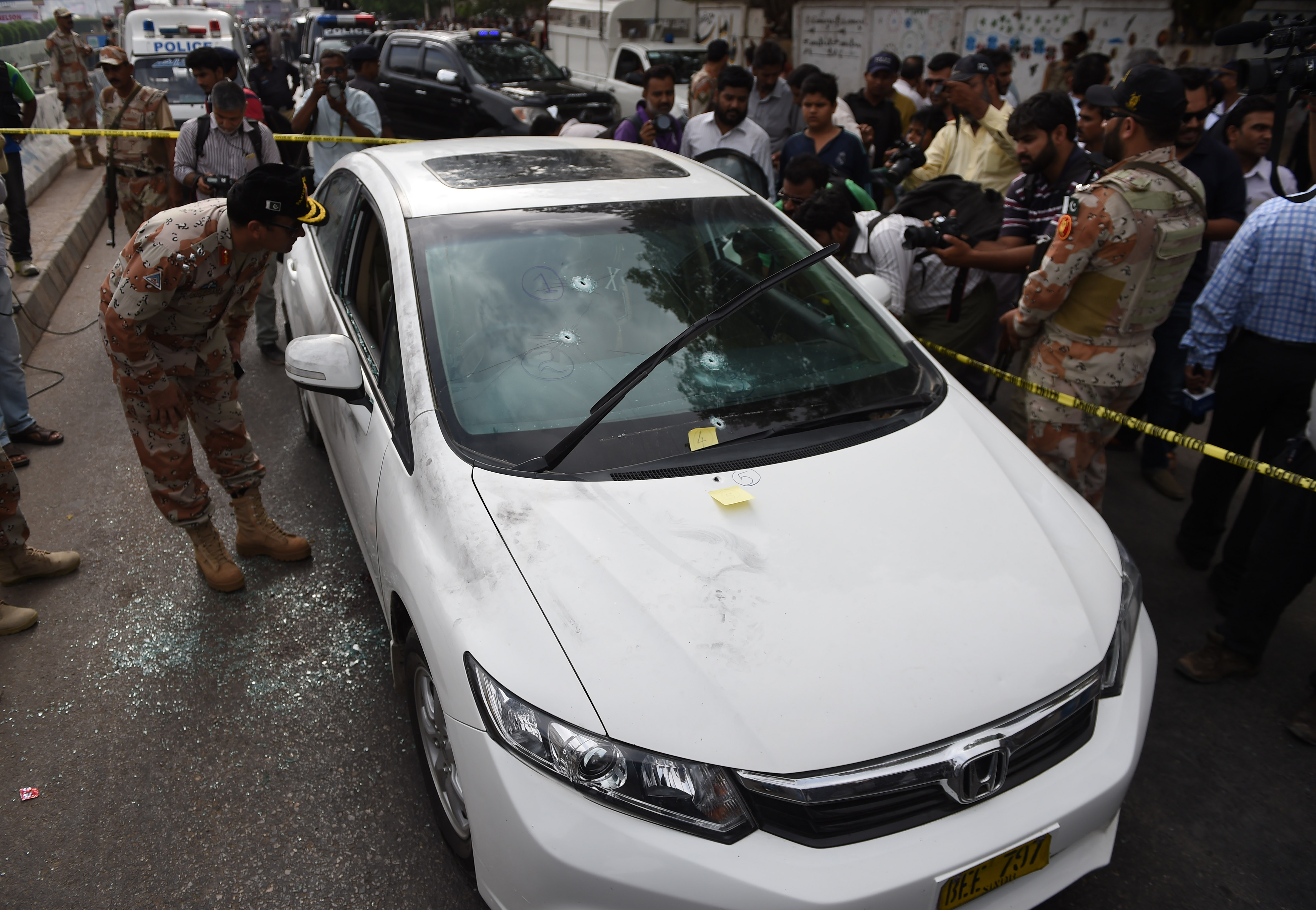 Pakistani security officials inspect the bullet-riddled car of Sufi musician Amjad Sabri who was killed in an attack by unknown gunmen, at a morgue in Karachi on June 22, 2016. (ASIF HASSAN—AFP/Getty Images)