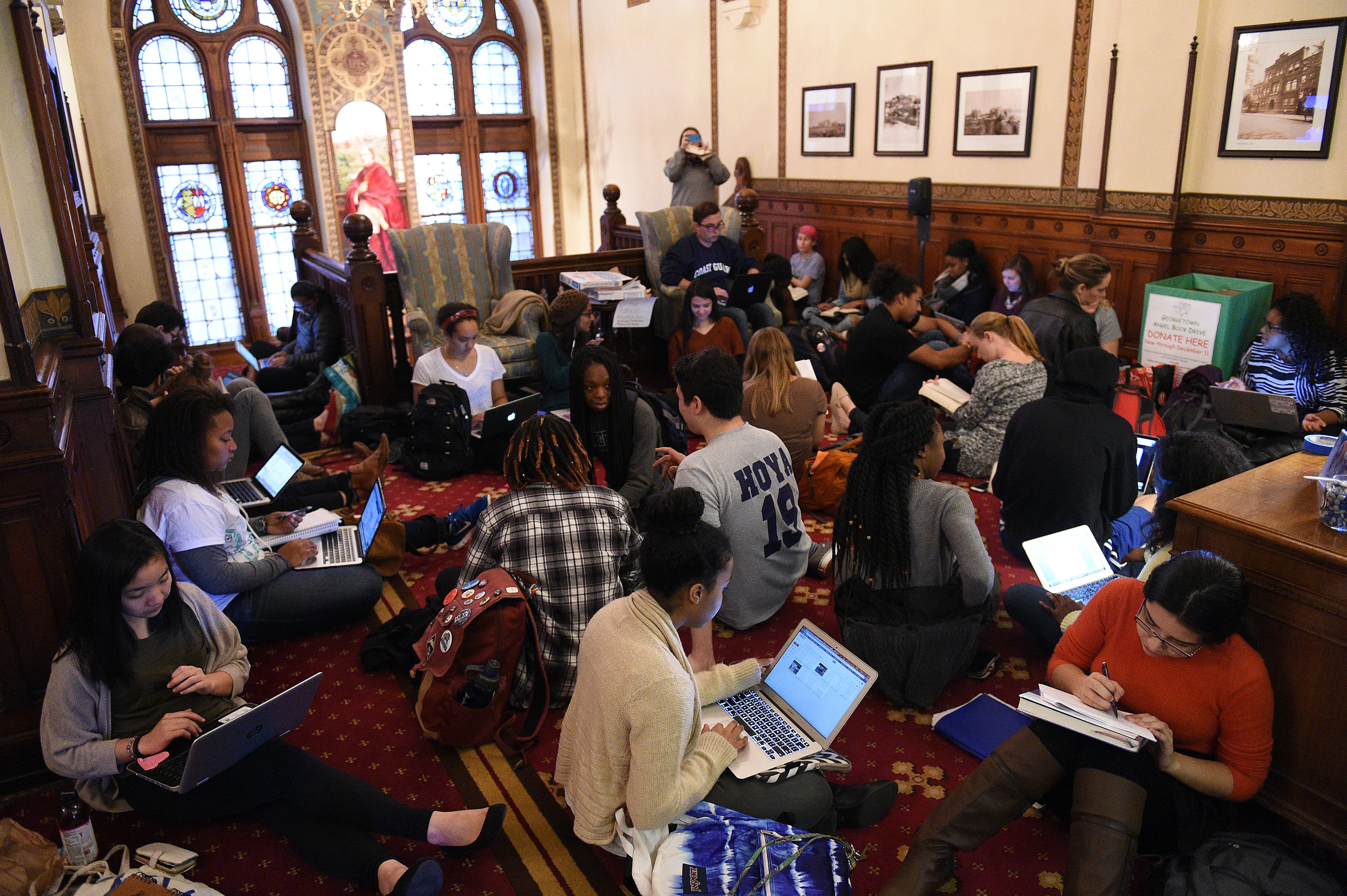Around 30 students sit in in front of the office of John J. DeGioia, president of Georgetown University in Washington, D.C., on November 13, 2015. The sit in was in solidarity with other student protests throughout the country addressing racial discrimination on campus. The students also demanded the change of the name of Mulledy Hall on campus. The hall was named after former University President Fr. Thomas F. Mulledy, S.J., who completed his term as president in of Georgetown University in 1838. After his term, Mulledy authorized the sale of 272 slaves owned by the Society of Jesus in Maryland. (Astrid Riecken—The Washington Post/Getty Images)