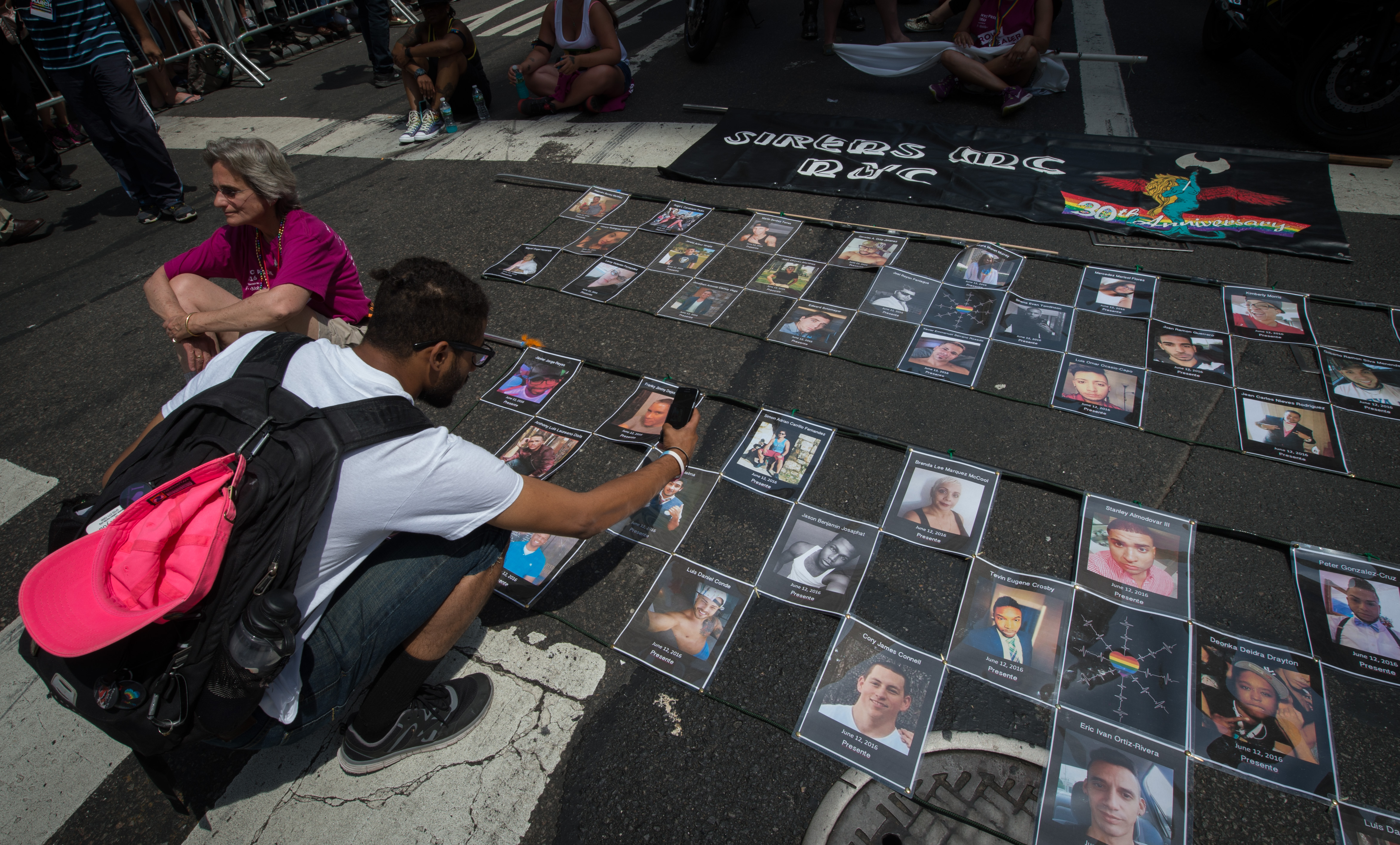 Photographs of the victims of the Orlando Pulse nightclub shooting are laid out prior to the start of the 46th annual gay-pride march in New York City on June 26, 2016 (Bryan R. Smith—AFP/Getty Images)