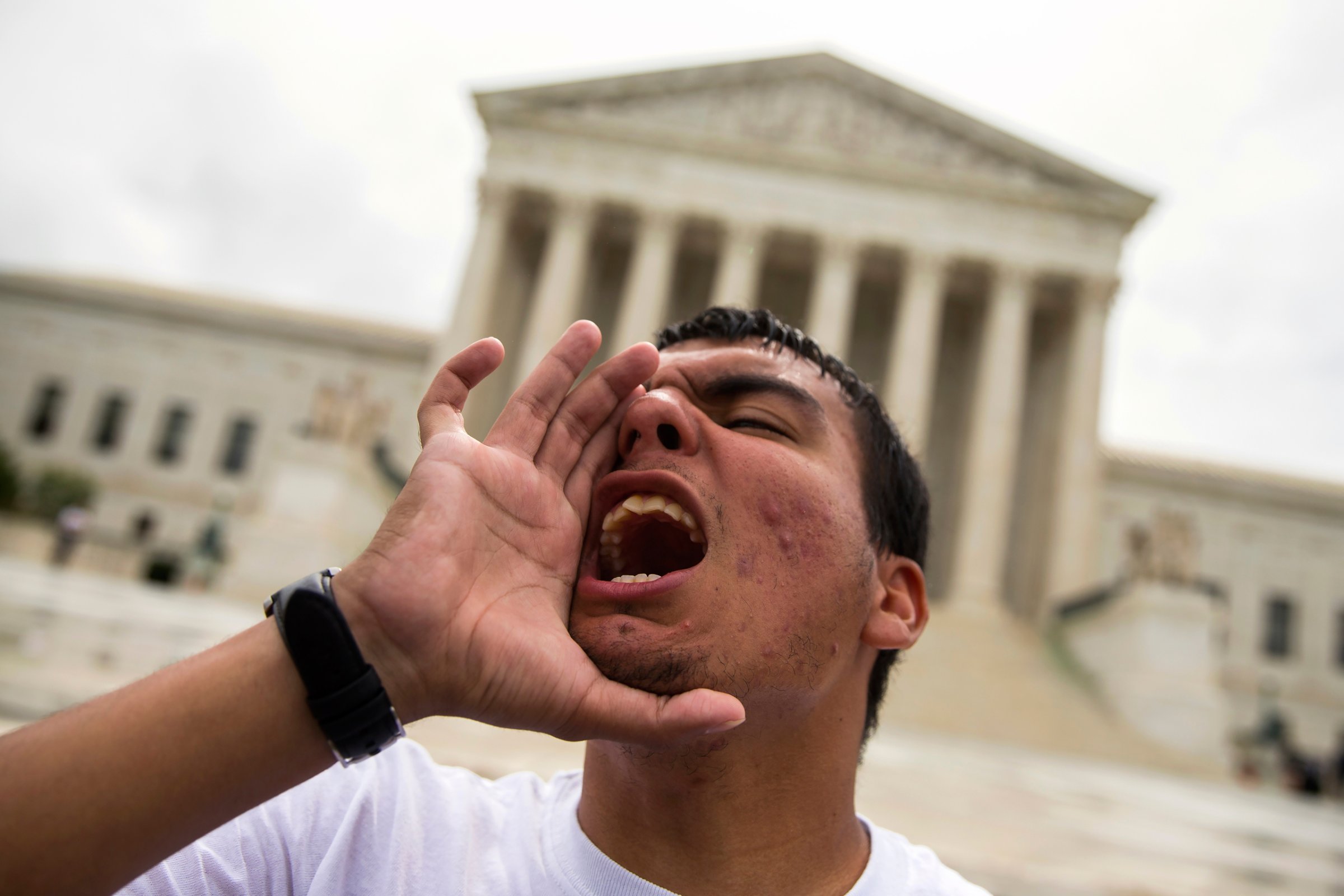 Gerson Quinteron of Washington, yells during a demonstration on immigration at the Supreme Court in Washington, Thursday, June 23, 2016. A tie vote by the Supreme Court is blocking President Barack Obama's immigration plan that sought to shield millions living in the U.S. illegally from deportation. The justices' one-sentence opinion effectively kills the plan for the duration of Obama's presidency. (AP Photo/Evan Vucci)