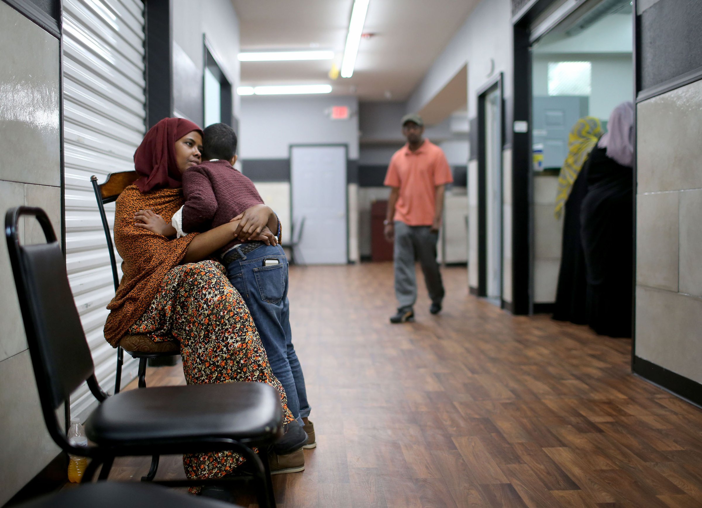 Ayan Farah, the mother of defendent Mohamed Farah, 22, hugs her youngest son outside the family's restaurant in the Karmel Mall in Minneapolis, Minn., June 3, 2016.