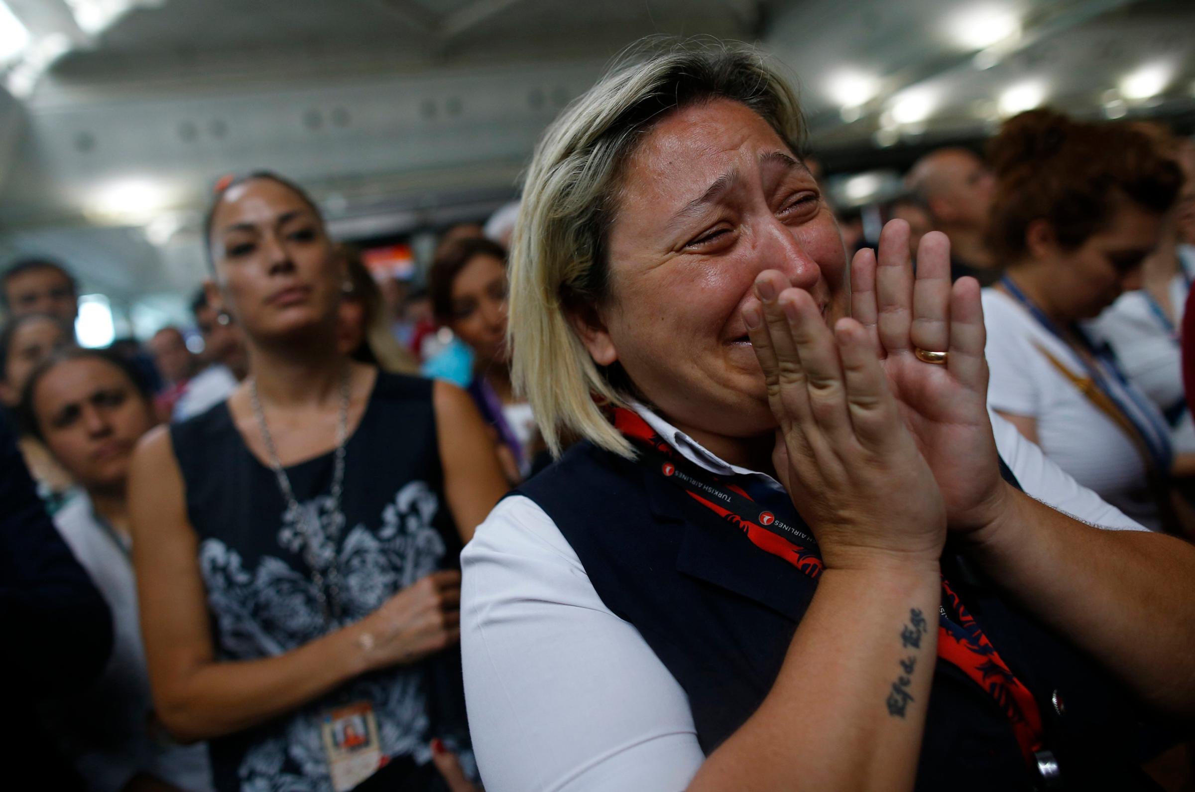 A woman reacts as family members, colleagues and friends of the victims of Tuesday's blasts gather for a memorial ceremony at Ataturk Airport in Istanbul on June 30, 2016.