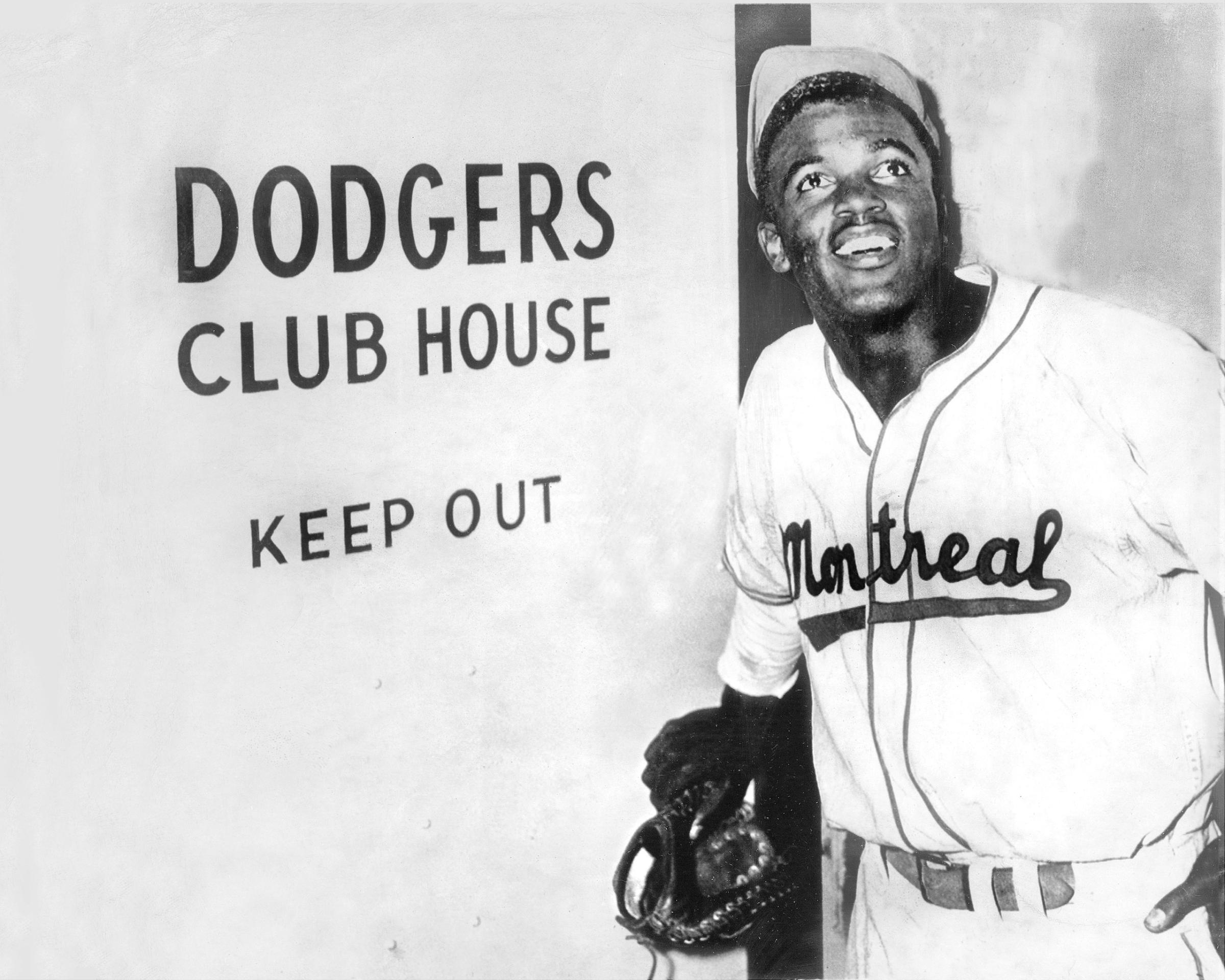 Jackie Robinson, the first black to be admitted to the major leagues, enters the Brooklyn Dodgers' clubhouse after the Dodgers announced they had purchased his Montreal Expo contract, 1947.