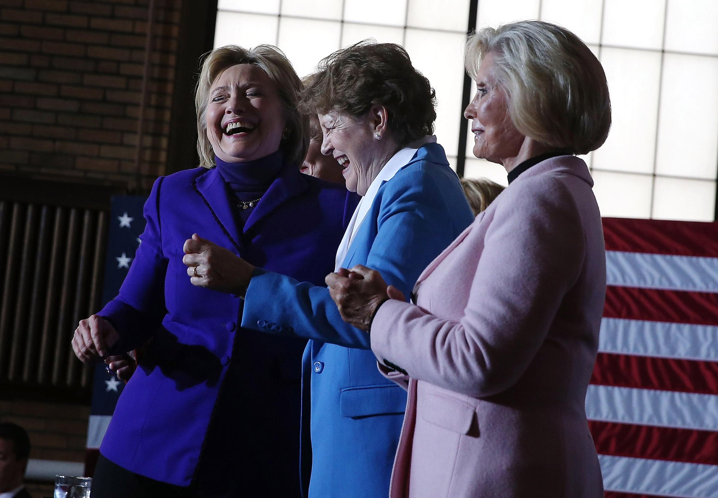 Democratic presidential candidate former Secretary of State Hillary Clinton dances with U.S. Sen. Jeanne Shaheen (center) and Lilly Ledbetter during a canvas kickoff event at the YWCA of Manchester in Manchester, New Hampshire on Feb. 5, 2016.