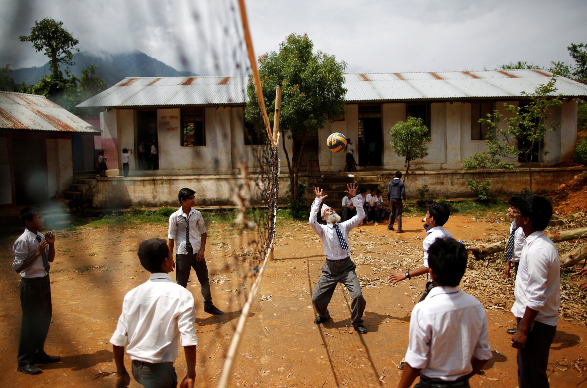 Durga Kami, 68, who is studying in the tenth grade at Shree Kala Bhairab Higher Secondary School, plays volleyball with friends during a break in Syangja, Nepal, June 5, 2016. REUTERS/Navesh Chitrakar. SEARCH "DURGA KAMI" FOR THIS STORY. SEARCH "THE WIDER IMAGE" FOR ALL STORIES . TPX IMAGES OF THE DAY