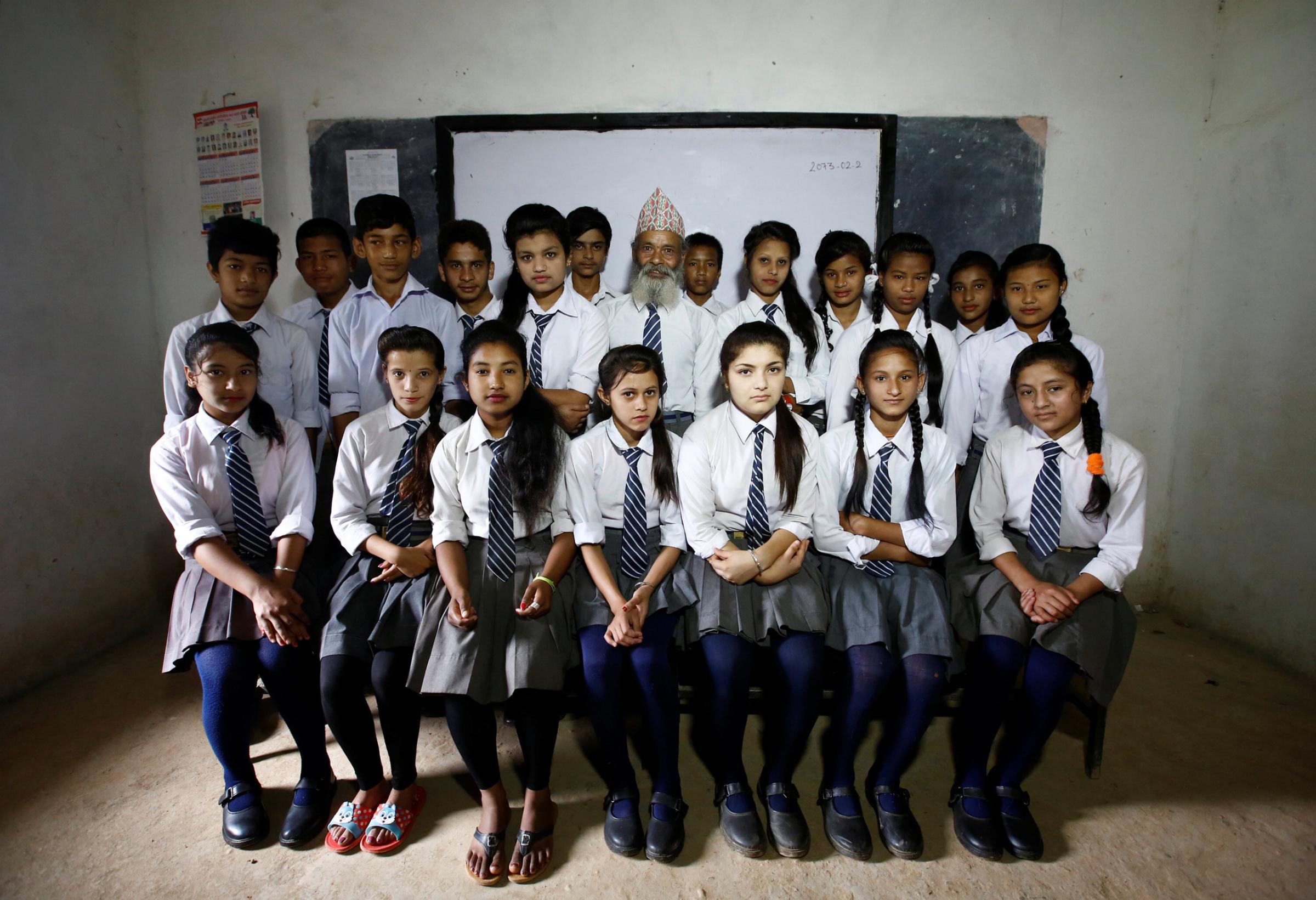 Durga Kami (C), 68, and his classmates pose for a group picture in their classroom at Shree Kala Bhairab Higher Secondary School in Syangja, Nepal, June 5, 2016. REUTERS/Navesh Chitrakar. SEARCH "DURGA KAMI" FOR THIS STORY. SEARCH "THE WIDER IMAGE" FOR ALL STORIES. TPX IMAGES OF THE DAY