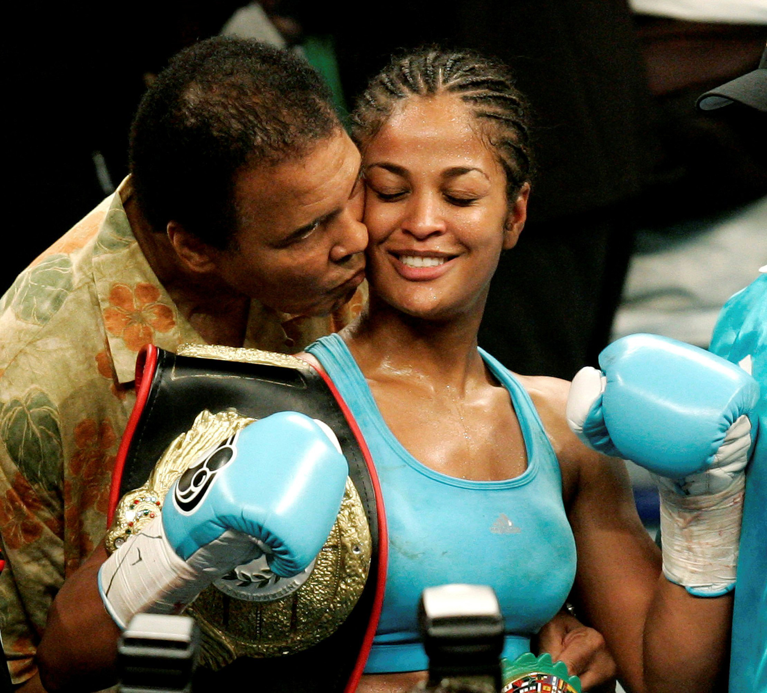 File photo of WBC and WIBA super middleweight champion Laila Ali being kissed by her father, boxing great Muhammad Ali, at the MCI Center in Washington