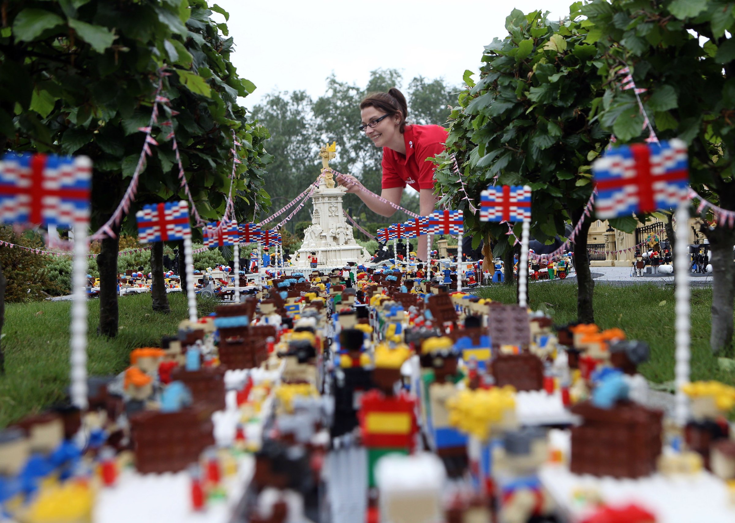 Legoland Windsor Resort model maker Kat James puts the finishing touches to a miniature street party outside a model of Buckingham Palace in Miniland ahead of the Patron's Lunch on The Mall in London to mark the Queen's official 90th birthday, June 8, 2016.
