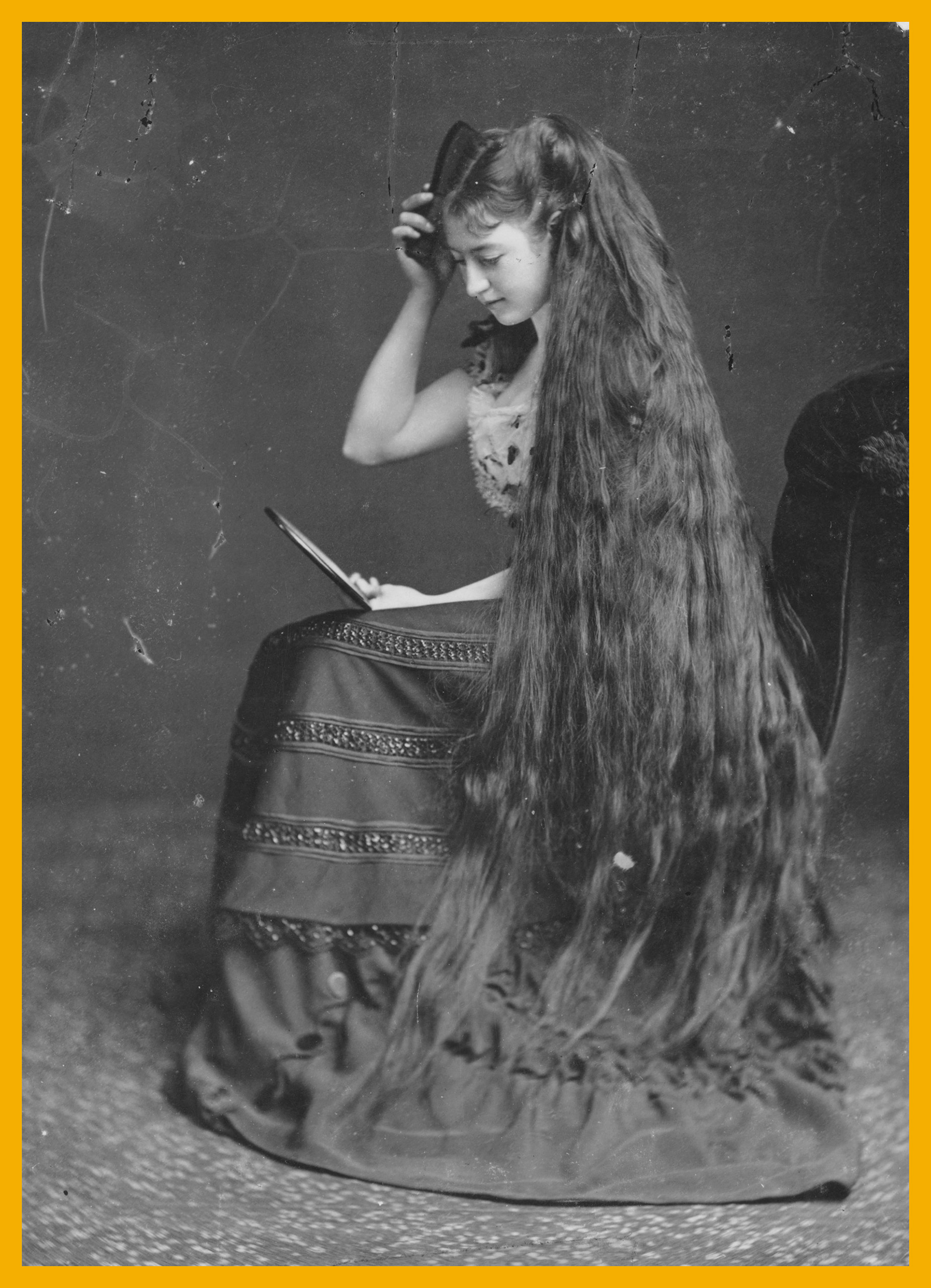 A woman combing her long hair circa 1885.