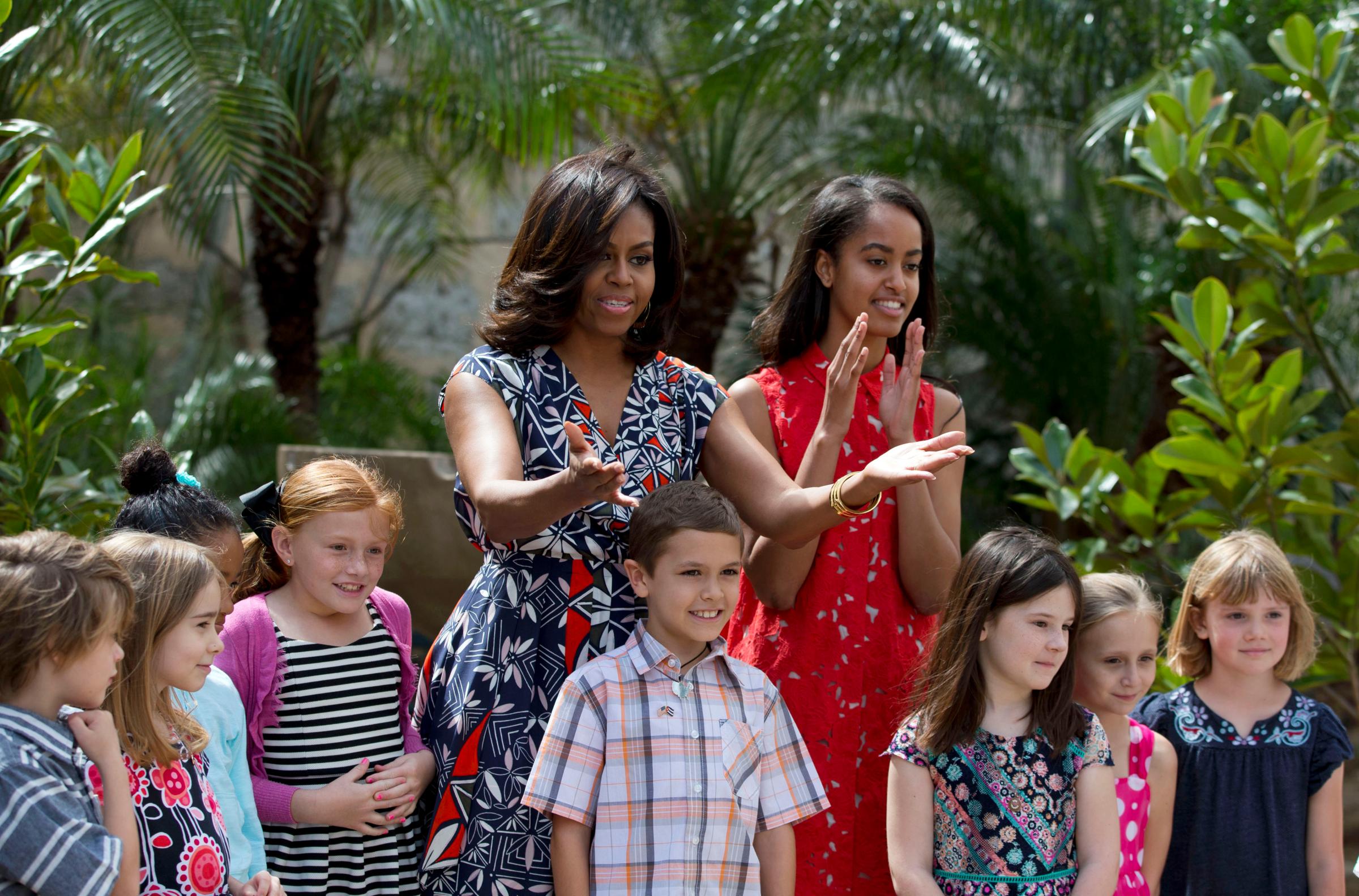 March 22, 2016 First Lady Michelle Obama thanks embassy workers with her daughter Malia after dedicating two magnolia trees and a bench, at a small park in Plaza de las Armas, Old Havana, Cuba.