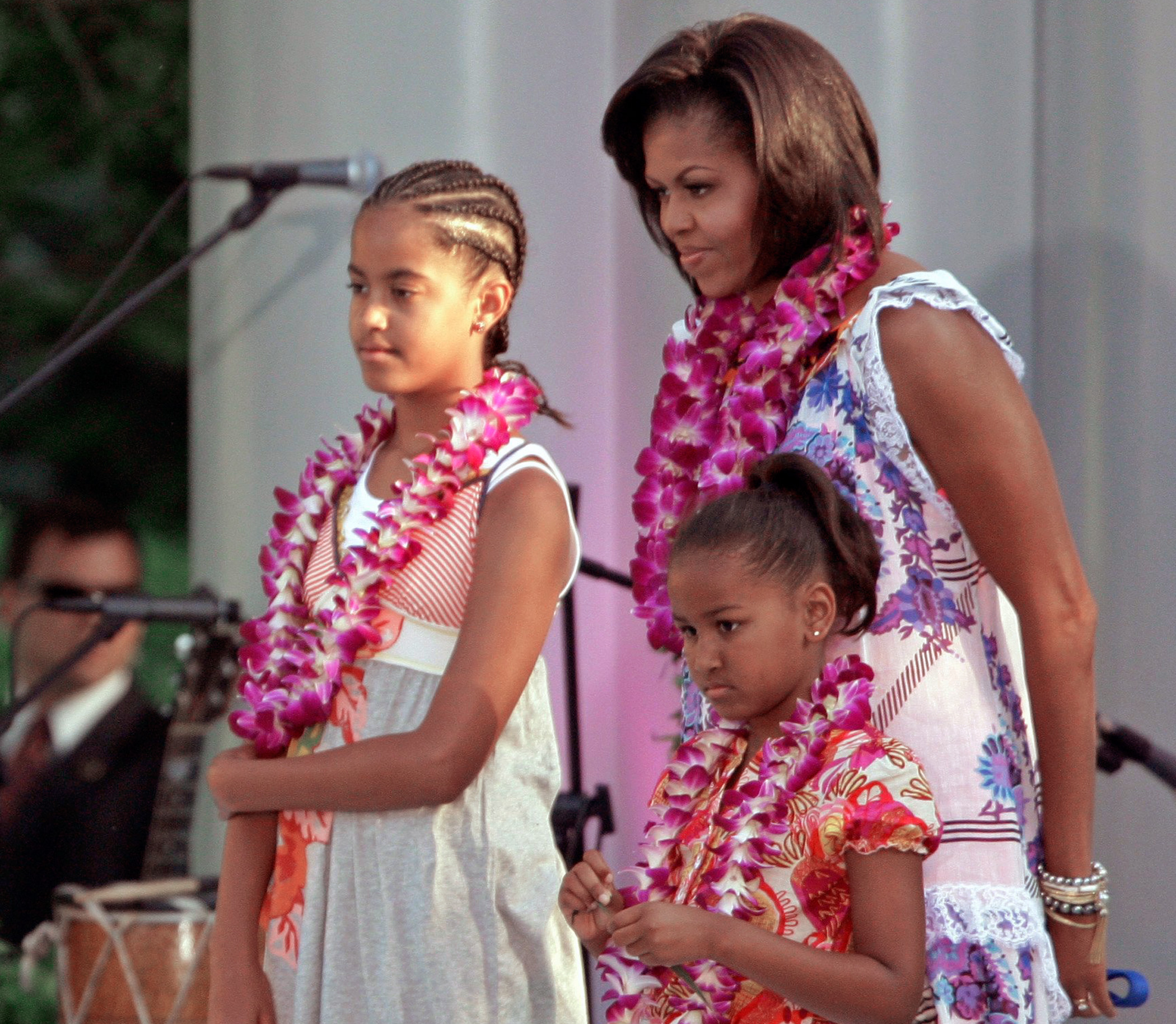 June 25, 2009 Malia Obama with mother Michelle and sister Sasha, attend a luau hosted by the president on the South Lawn of the White House for members of Congress and their families.