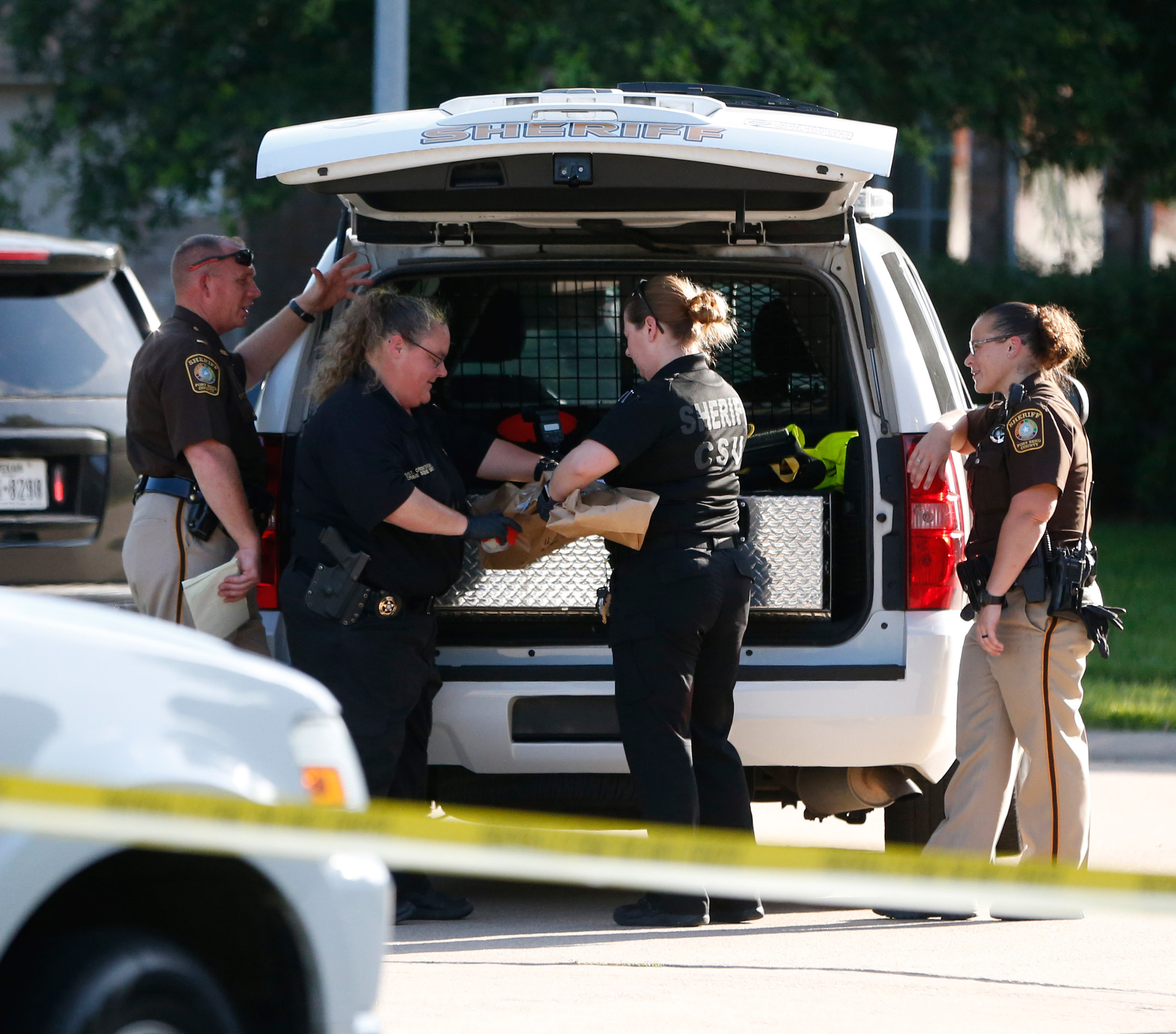 Fort Bend County Sheriffs department crime scene members bag a gun for evidence in a shooting in Katy, Tx., on June 24, 2016. (Karen Warren—Houston Chronicle/AP)