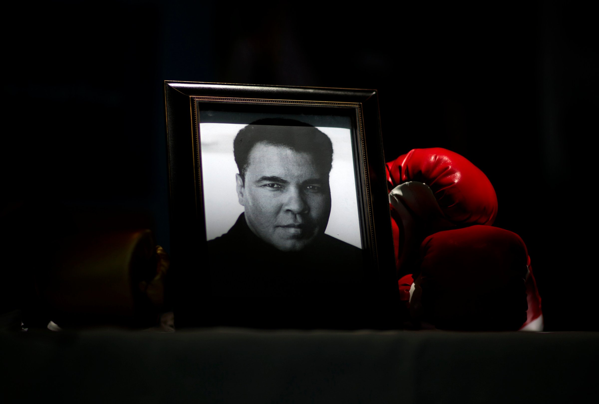 A portrait of Muhammad Ali is displayed next to a pair of boxing gloves at the I Am Ali Festival at the Kentucky Center for the Performing Arts, in Louisville, June 8, 2016.