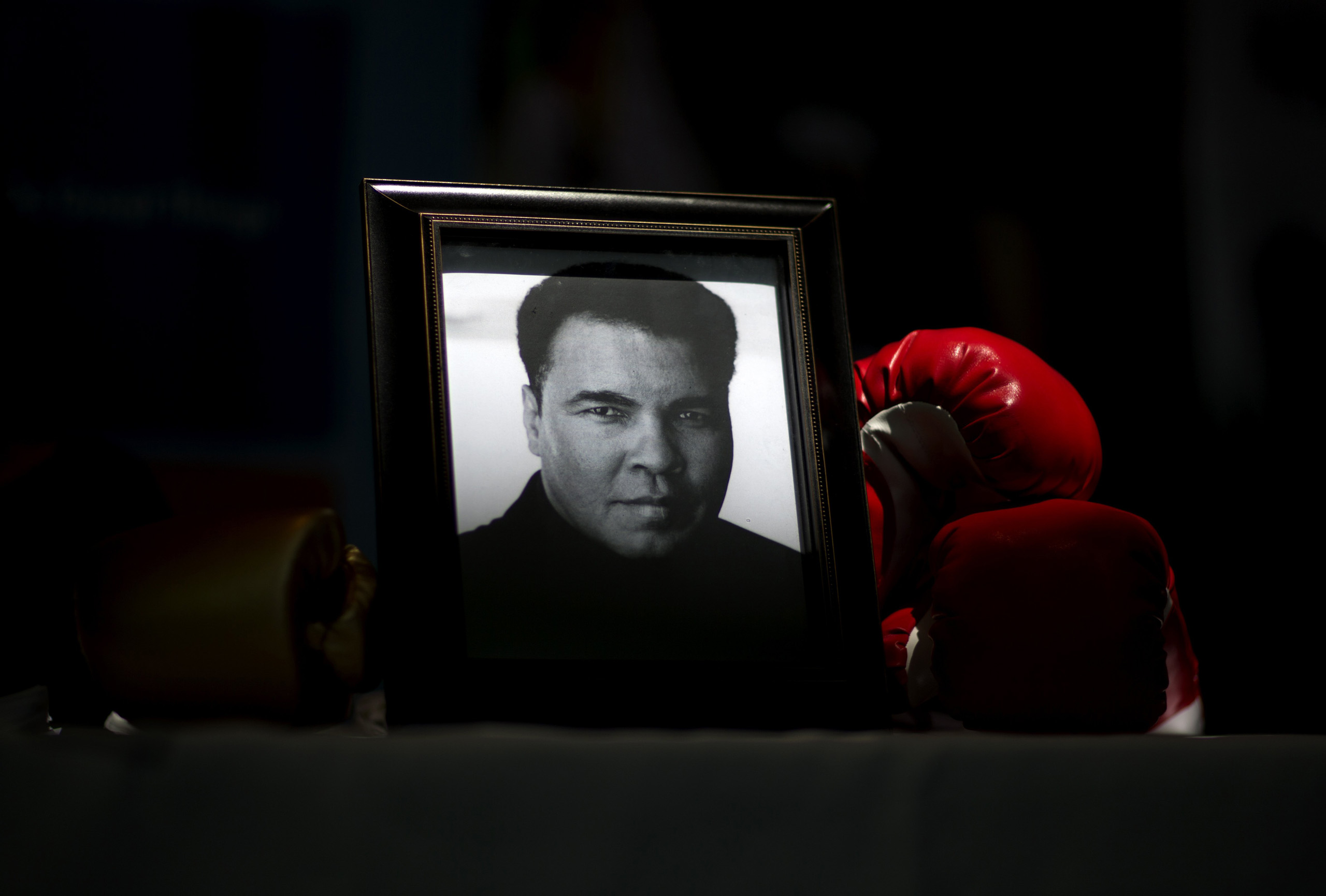 A portrait of Muhammad Ali is displayed next to a pair of boxing gloves at the I Am Ali Festival at the Kentucky Center for the Performing Arts, in Louisville, June 8, 2016. (David Goldman—AP)