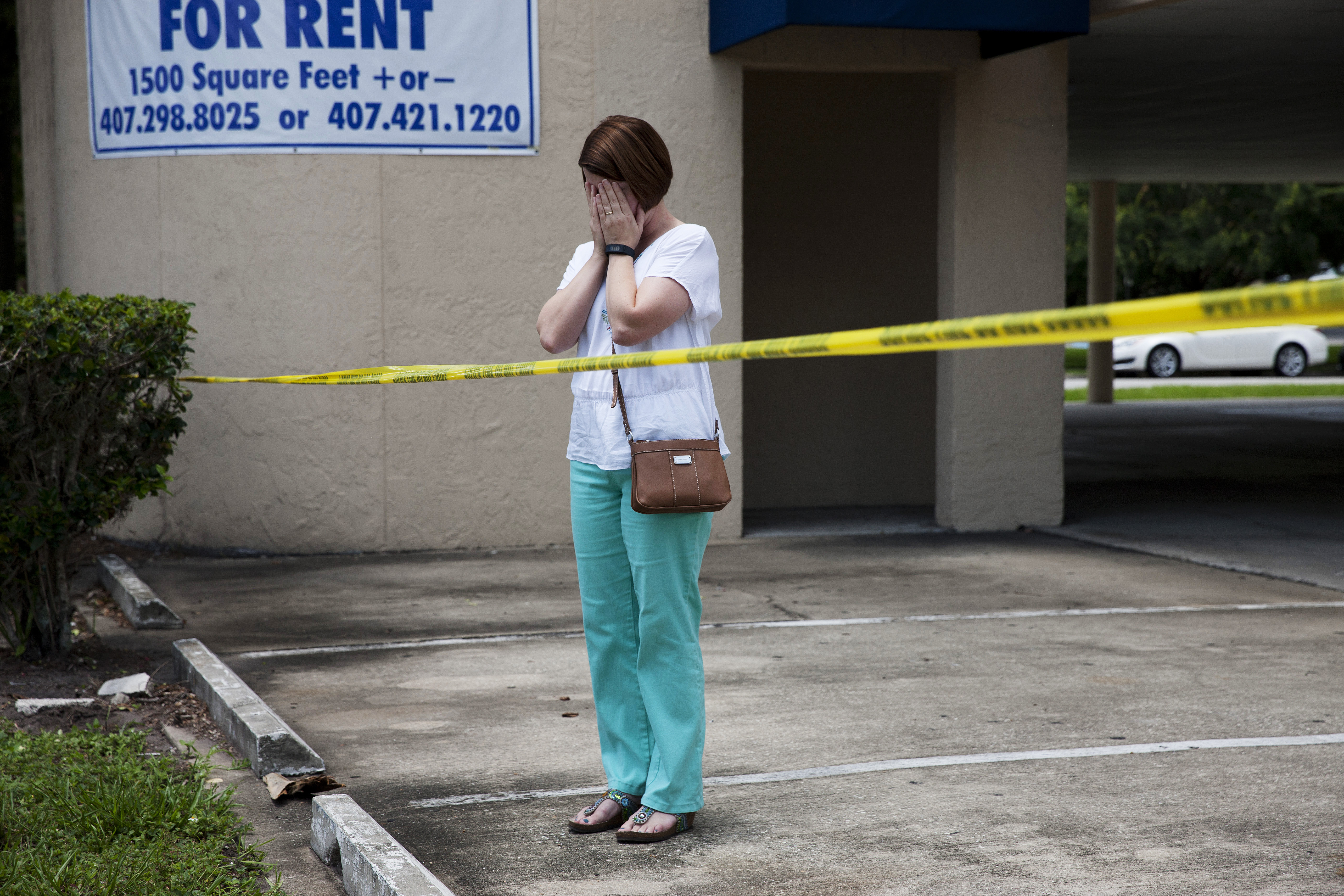 A woman reacts as authorities investigate Pulse following a mass shooting in Orlando, Fla., on June 12, 2016.