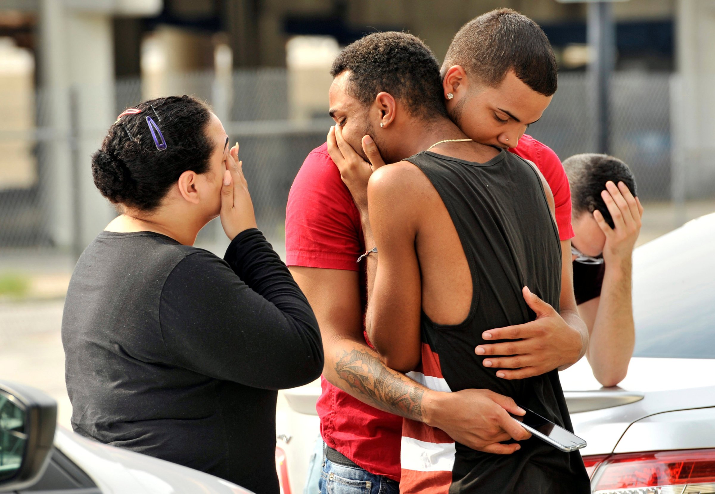 Friends and family members embrace outside the Orlando Police Headquarters during the investigation of a shooting at the Pulse nightclub in Orlando, Fla., on June 13, 2016.