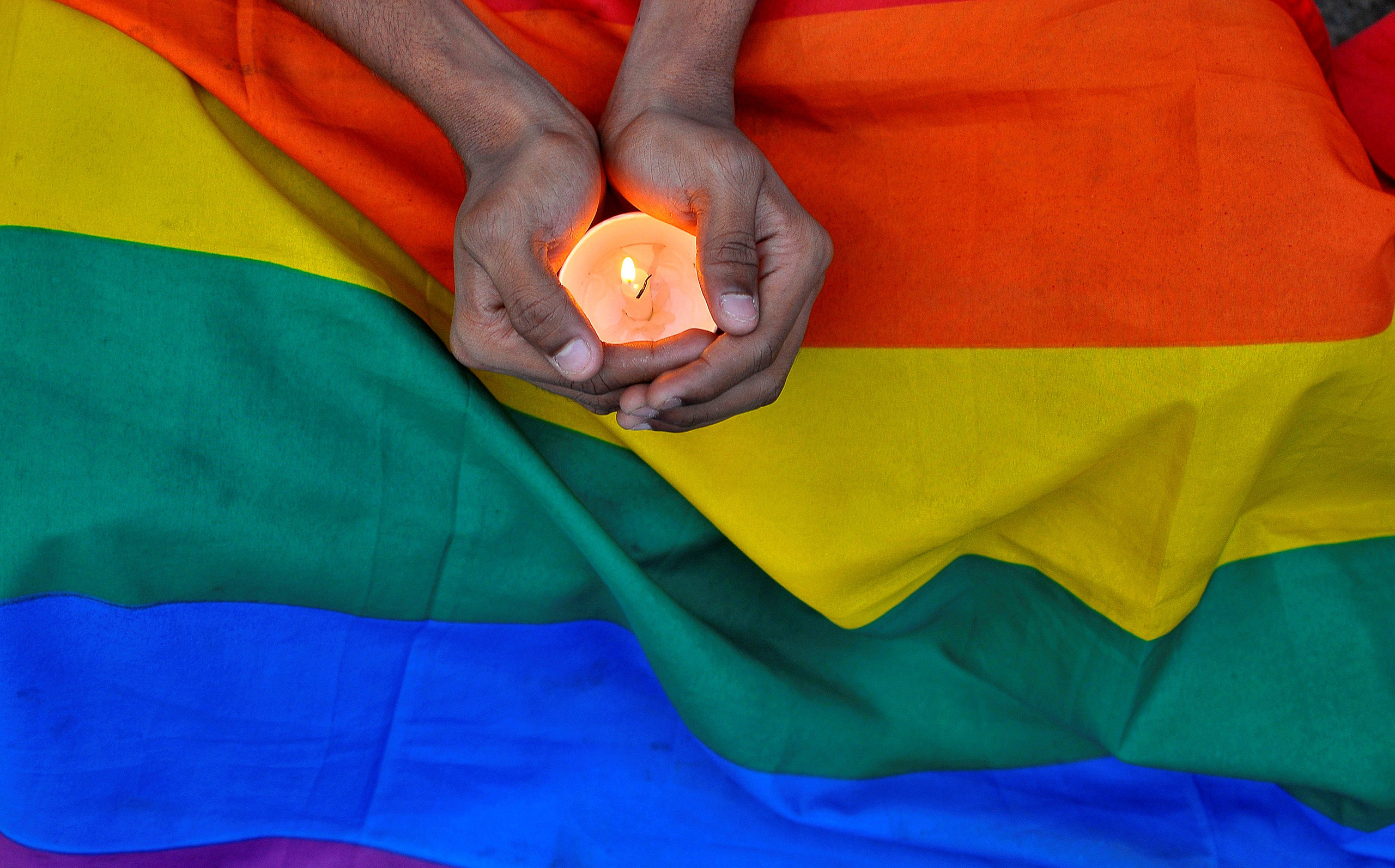 A member of the LGBT community in Bengalaru holds a candle during a memorial service following a mass shooting at the Pulse gay nightclub in Orlando