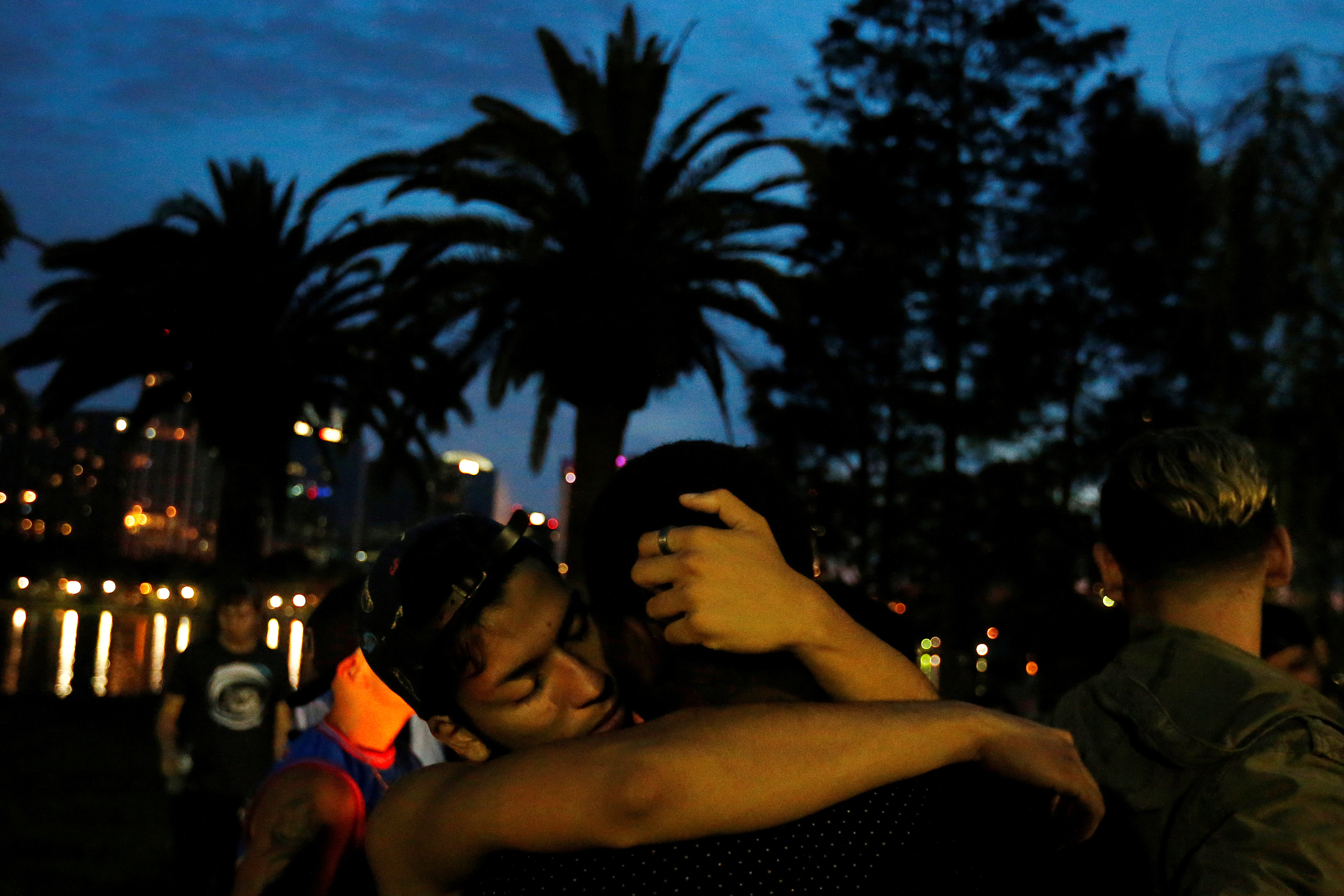 Men hug during a vigil in a park following a mass shooting at the Pulse gay nightclub in Orlando Fla., on June 12, 2016. (Carlo Allegri—Reuters)