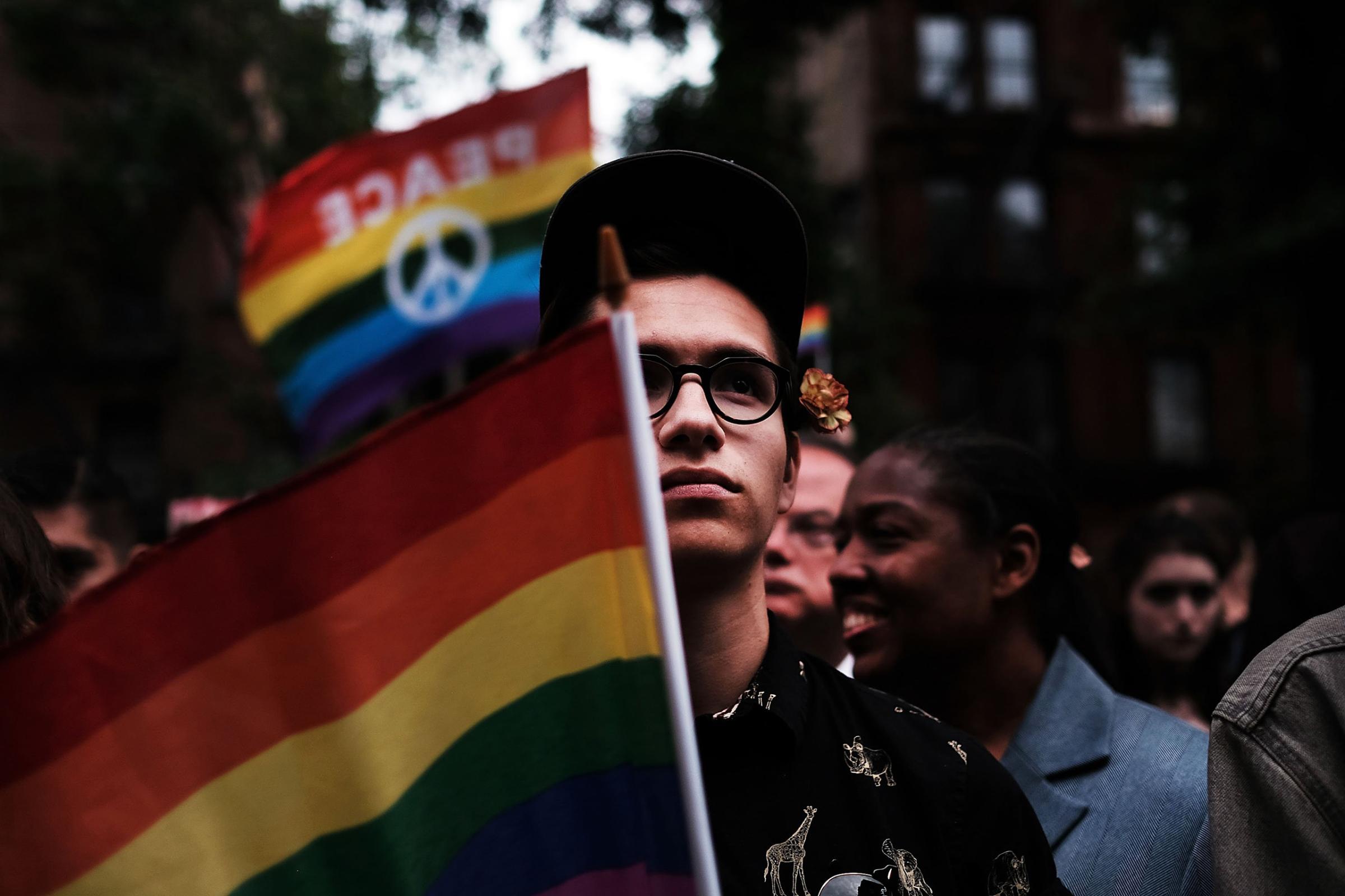 Hundreds of people listen to speakers at a memorial gathering for those killed in Orlando in front of the iconic New York City gay and lesbian bar The Stonewall Inn on June 13, 2016.
